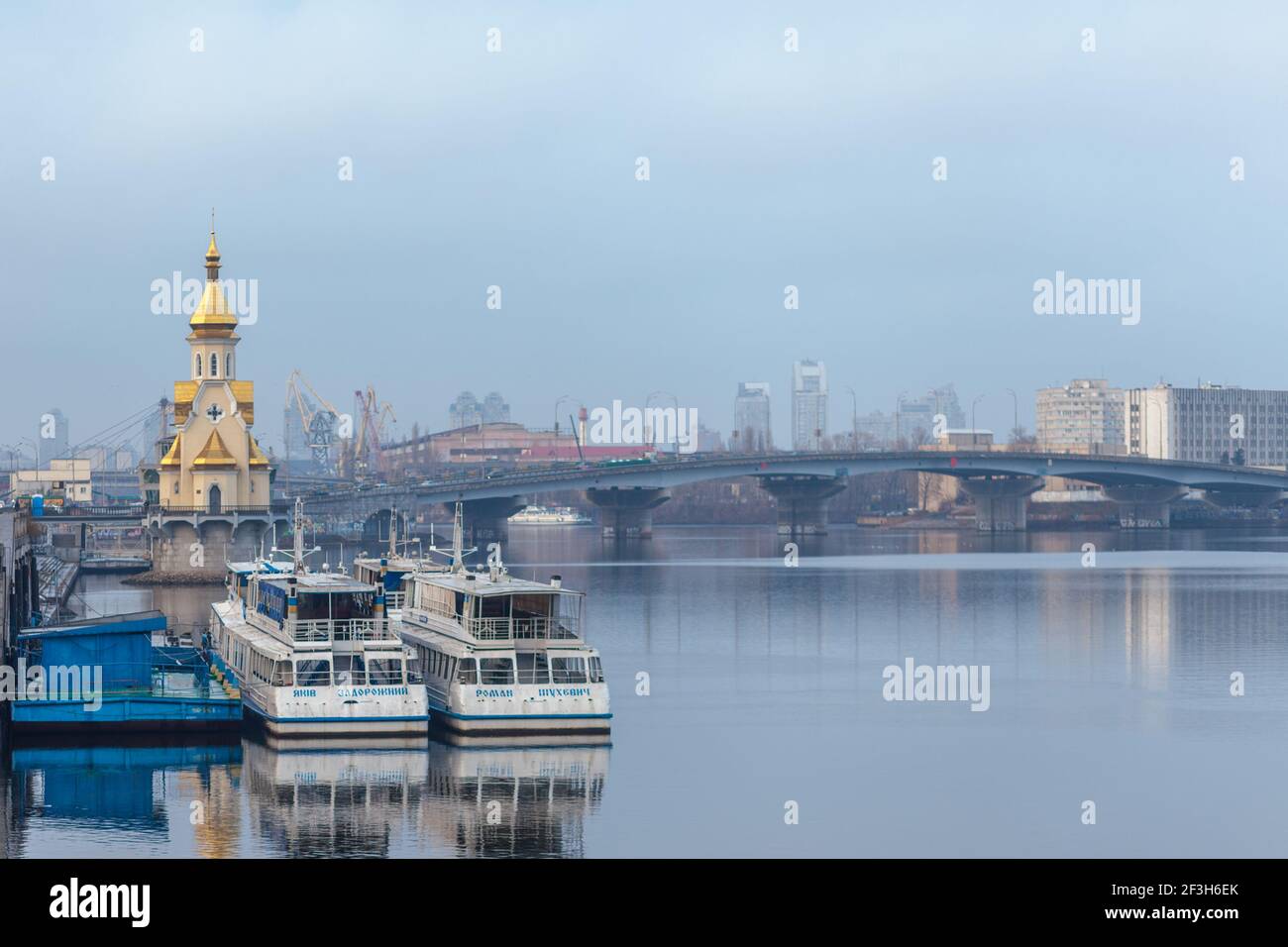 Ukraine, Kiev - January 9, 2020: Dnieper embankment and river station at Podil in Kiev. Moored pleasure boats for sightseeing excursions along the Dnieper River. Stock Photo