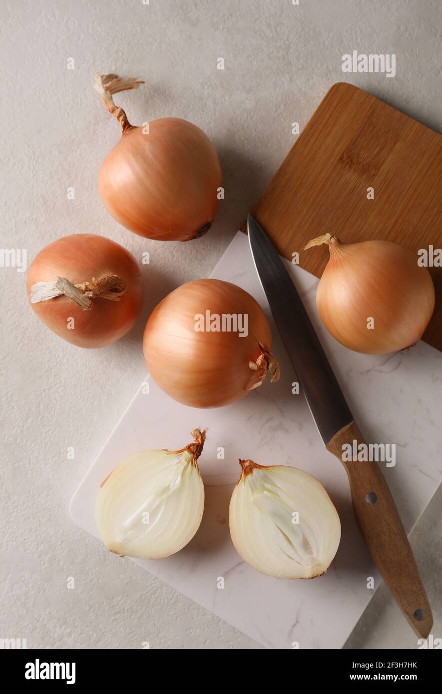 Marble - wooden board with fresh onion on white textured table Stock ...