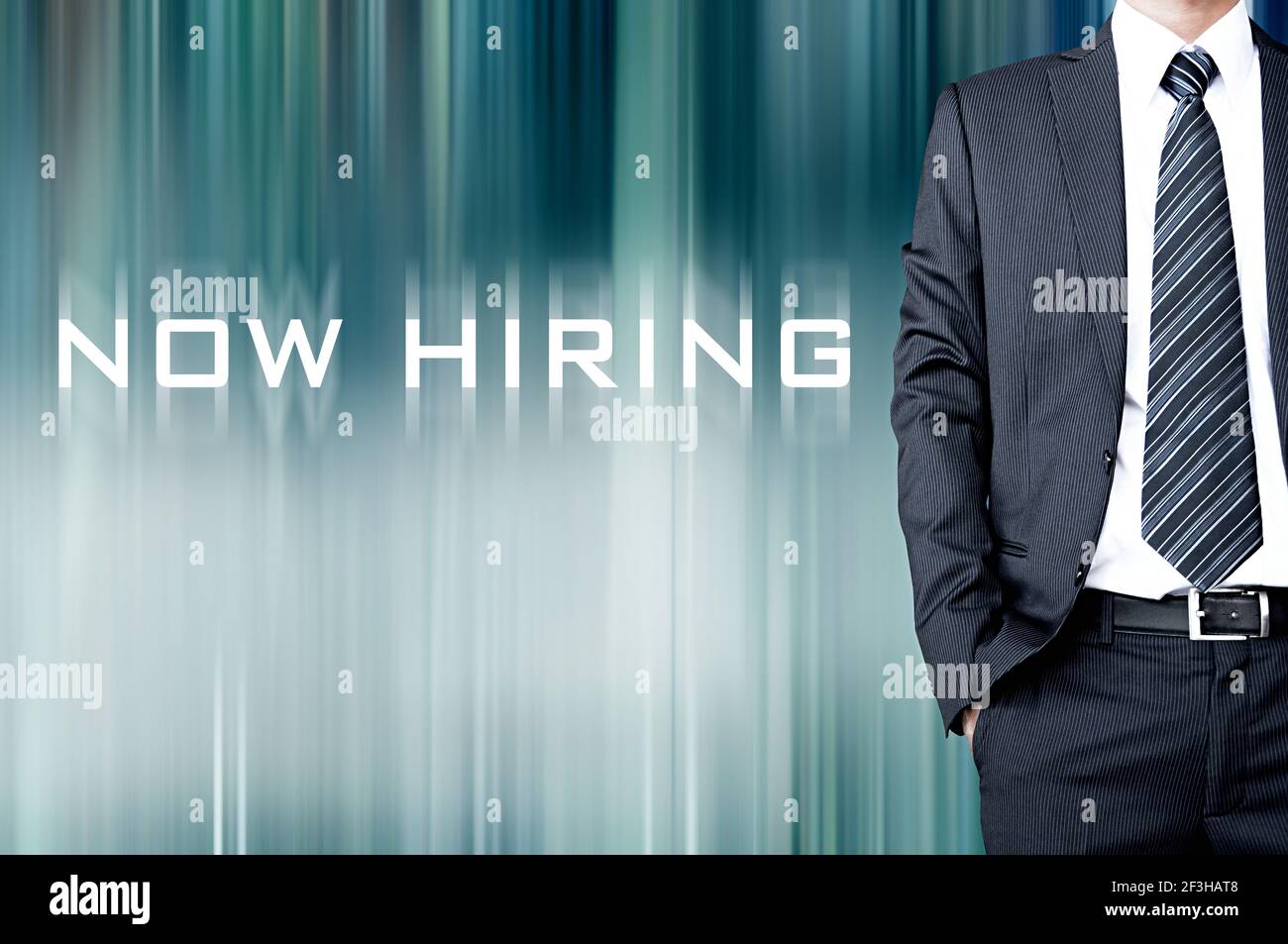 NOW HIRING sign on motion blur abstract background with standing businessman Stock Photo