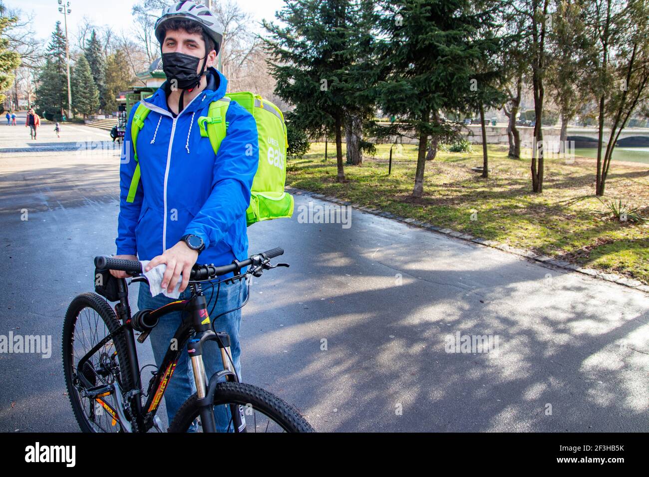Delivery man riding bike wearing mask Stock Photo