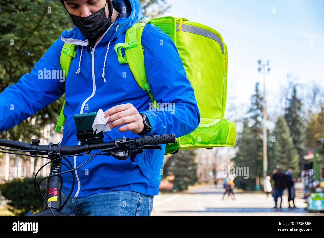 Delivery man riding bike wearing mask Stock Photo