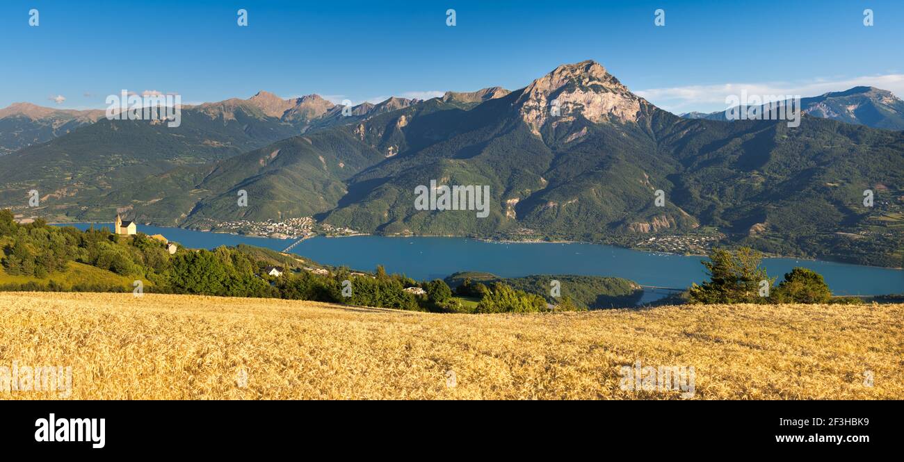 Serre-Poncon Lake and Grand Morgon Peak in summer with view on Savines-le-Lac village and the chapel of Saint-Apollinaire. Hautes-Alpes, Alps, France Stock Photo