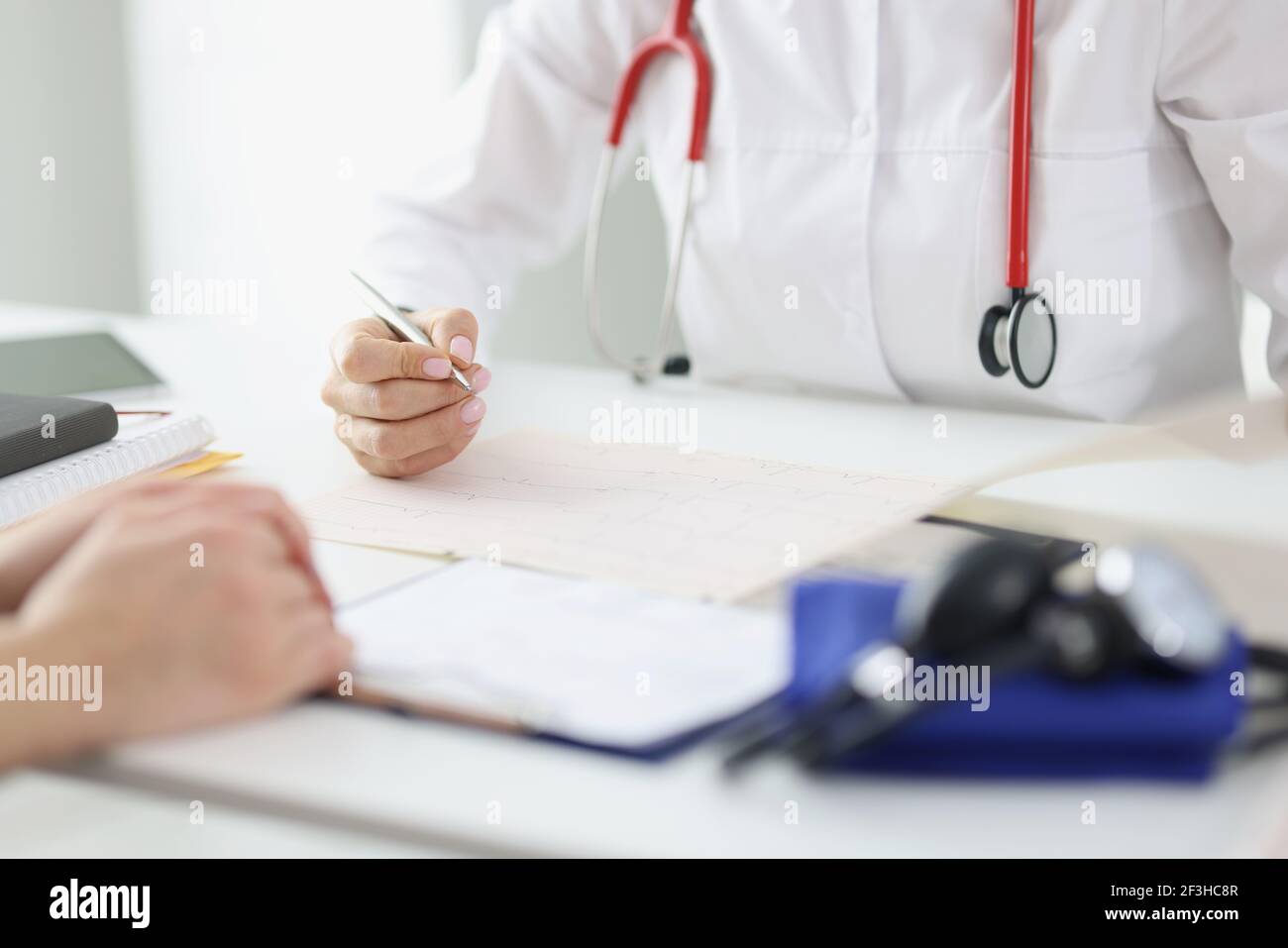 Doctor takes care of patient and makes entries in medical record Stock Photo
