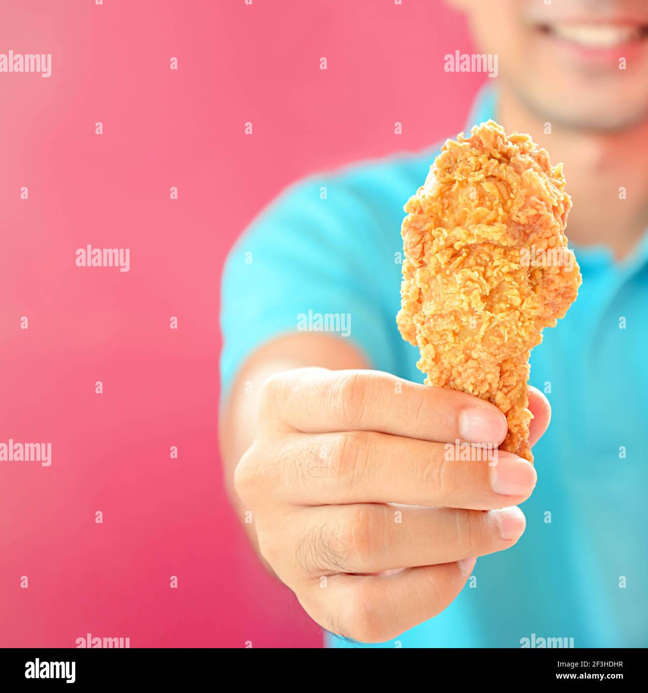A man giving fried chicken leg or drumstick Stock Photo Alamy