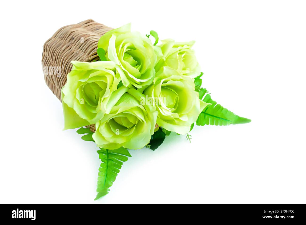Green flower bouquet in wicker basket on white background Stock Photo