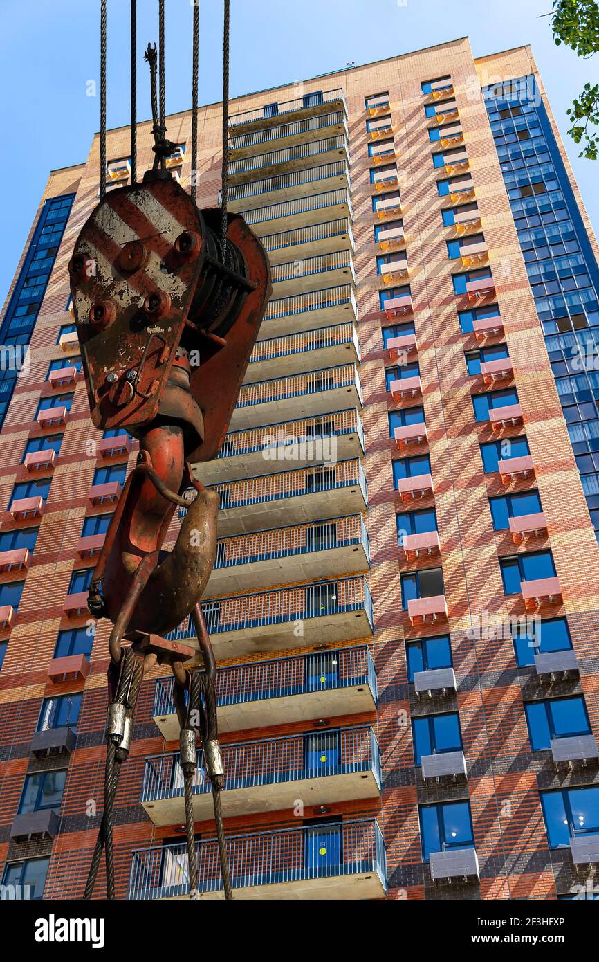 Construction crane hook with multi-storey building under construction ...