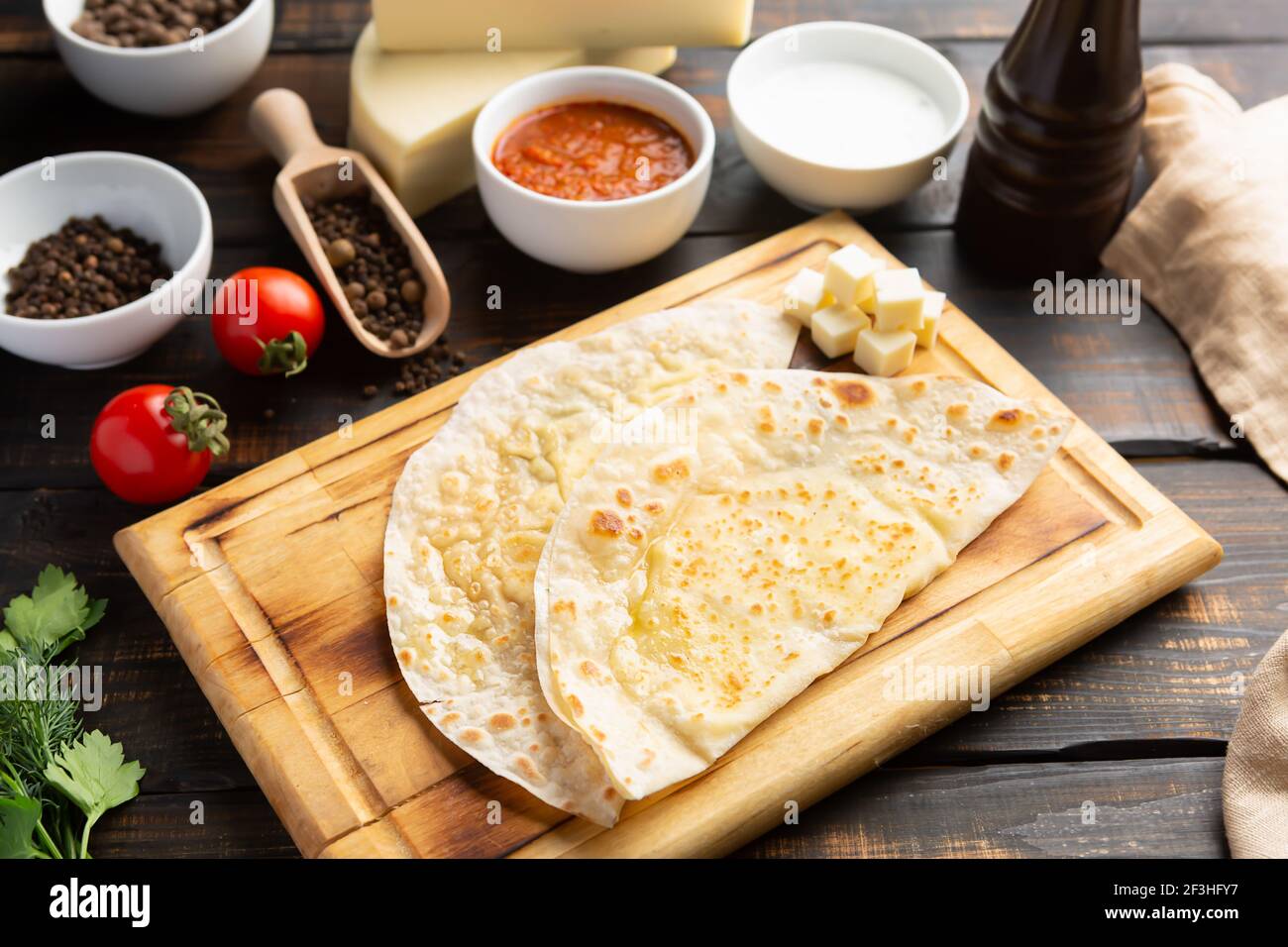 Azerbaijani national dish gutab with meat and vegetables together with yoghurt and sumac on wooden table Stock Photo