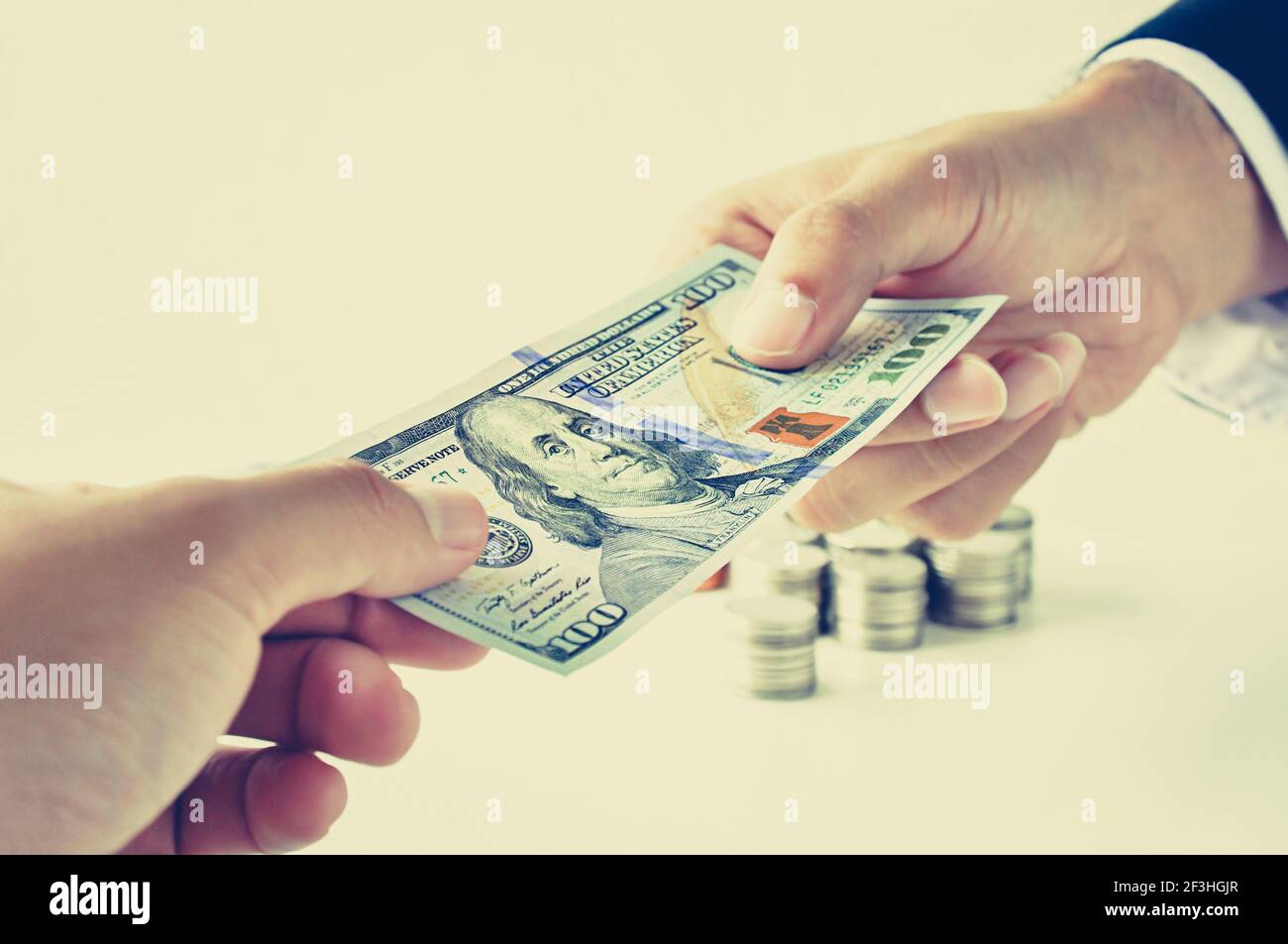 Hands giving & receiving money, 100 US dollars (USD) bill - vintage (retro) style color effect Stock Photo