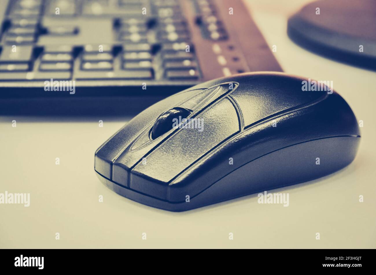 Black wireless mouse & computer keyboard on desktop - vintage (retro) style color effect Stock Photo