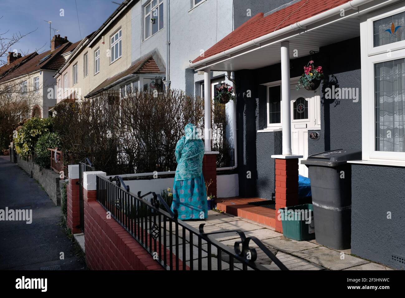 A female Asian standing outside her house in here garden in Bristol, UK Stock Photo