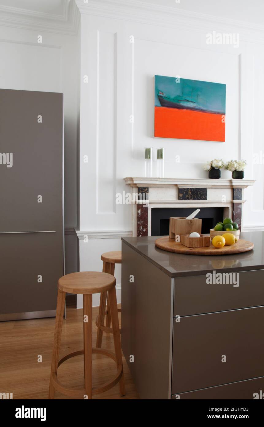 Kitchen island unit in front of marble fireplace | Architect: MAP Projects | Stock Photo