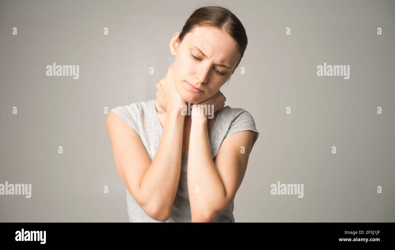 Tired woman feeling neck pain, massaging tense muscles Stock Photo - Alamy