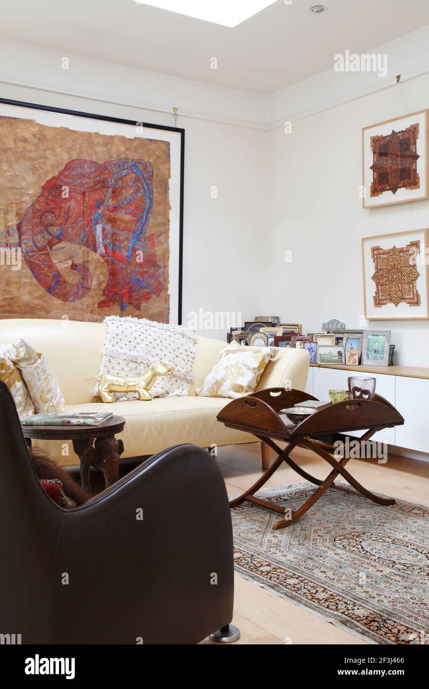 Corner of living room with large framed artwork of elephant's head on the wall | Architect: Silk Mews Architects | Stock Photo