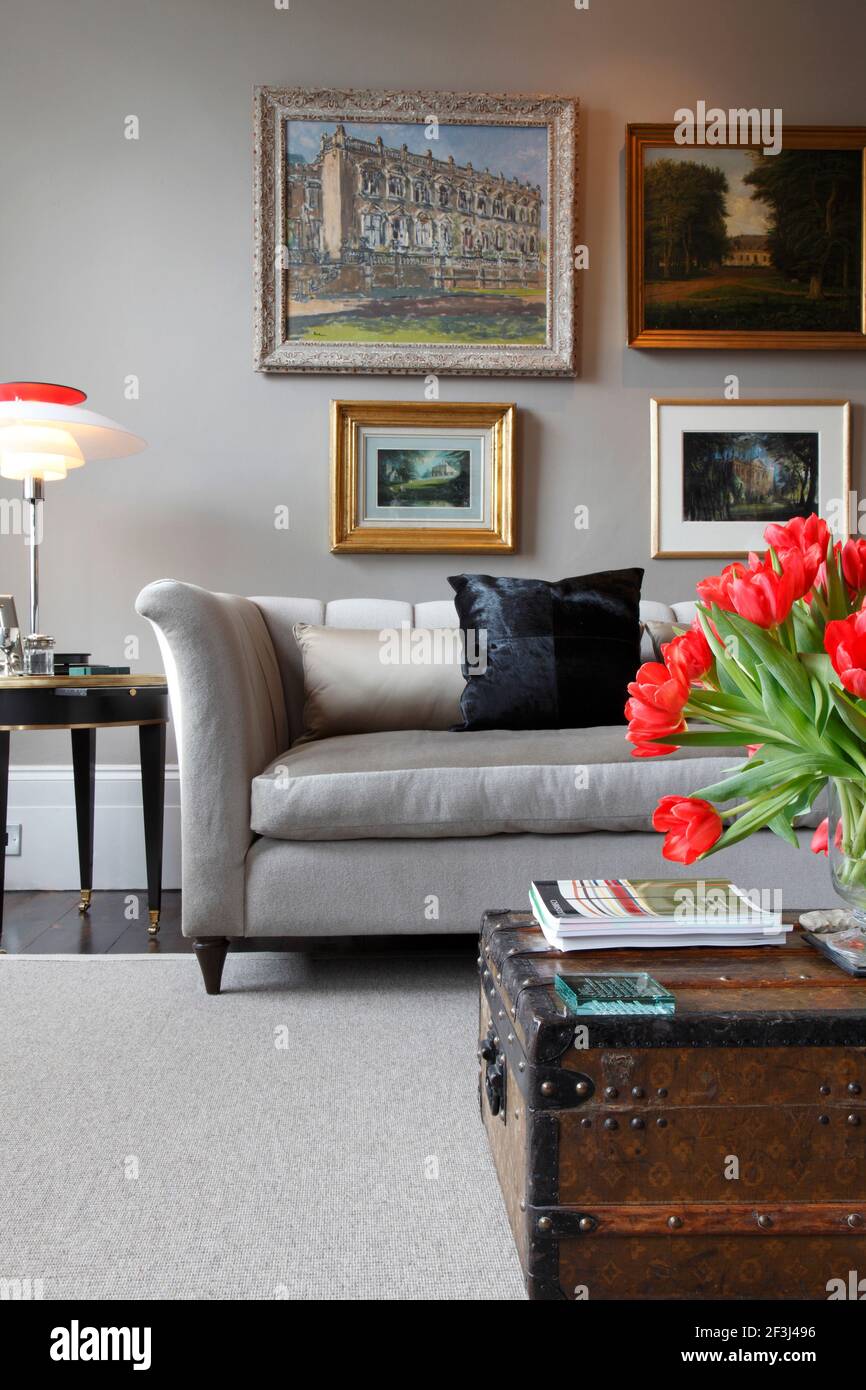 Grey sofa with modernist scandanavian lamp on side table and Louis Vuitton  trunk in foreground