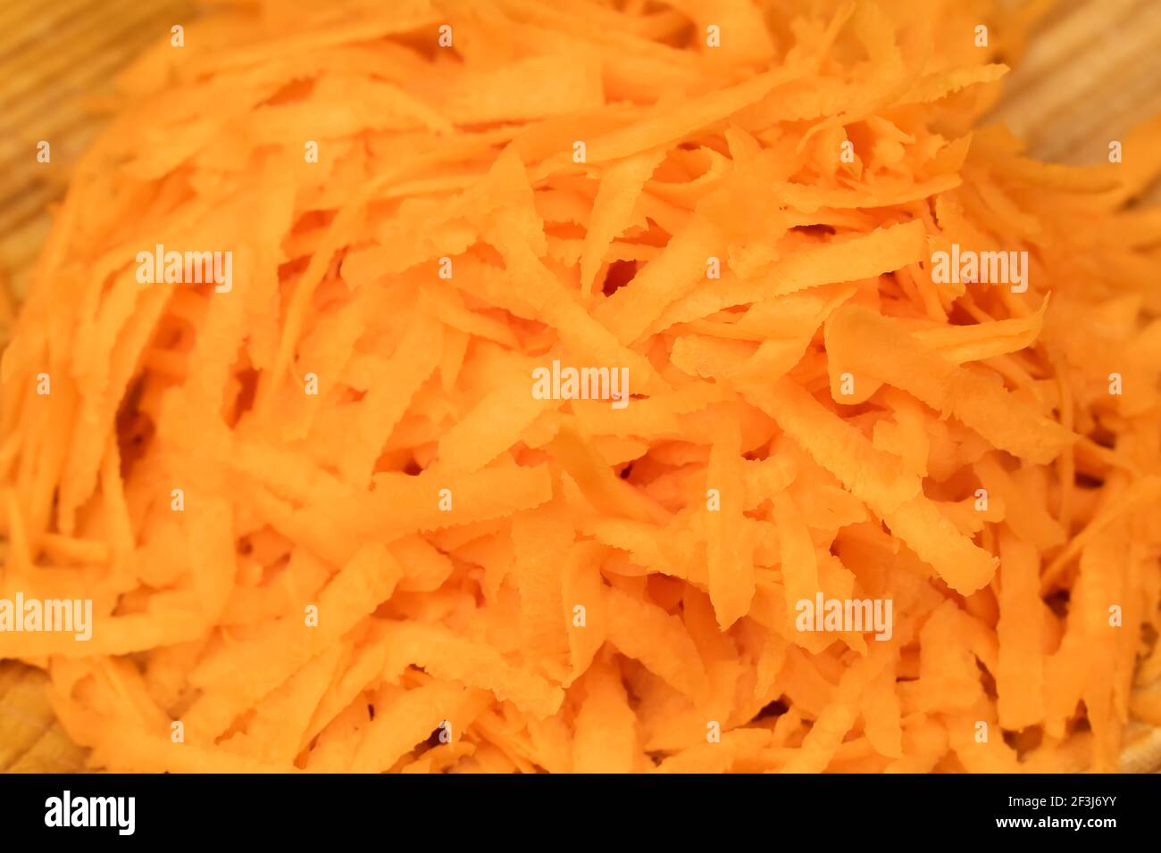 Grated fresh carrots on a plate background, macro Stock Photo
