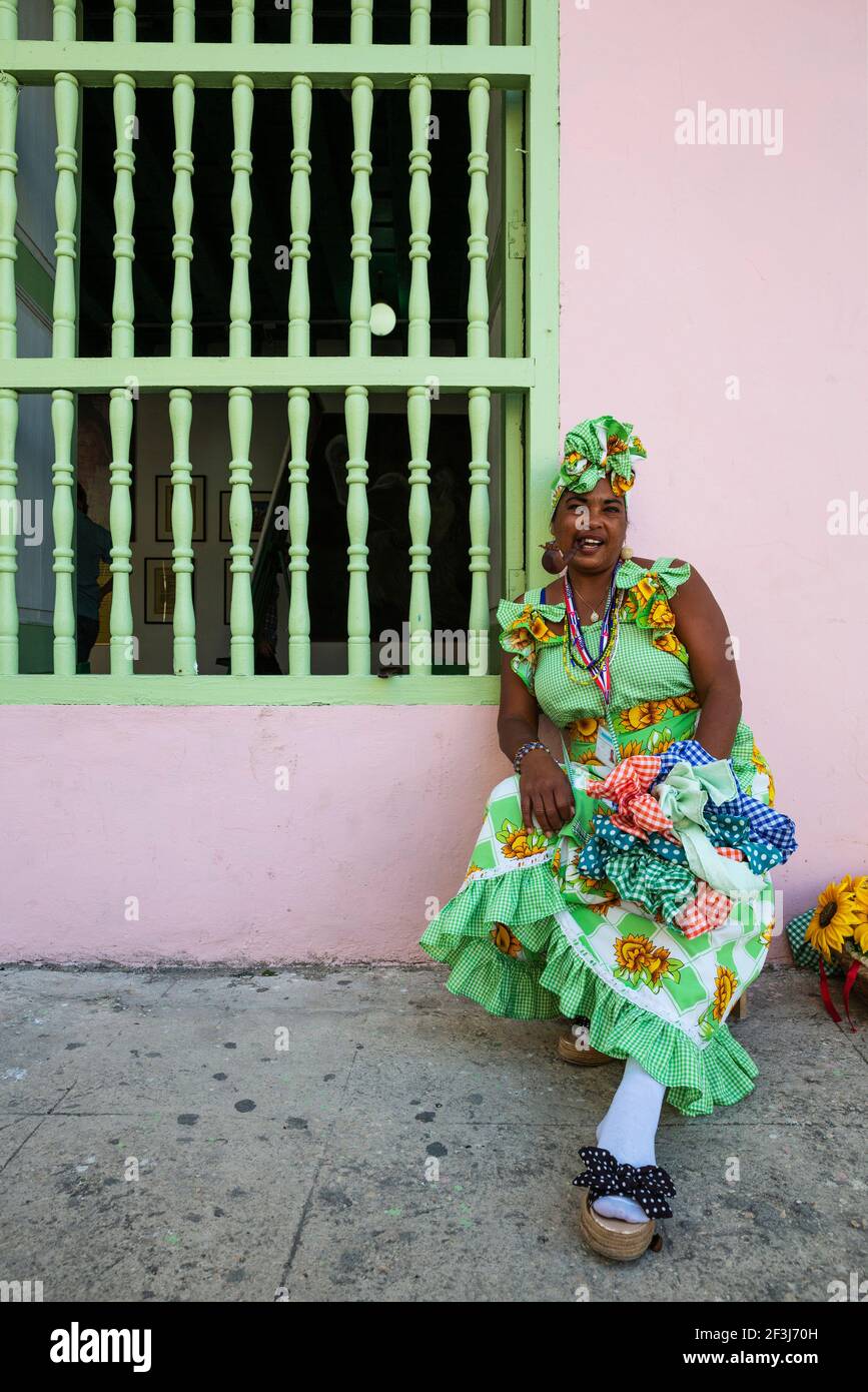 Some women in Habana Vieja wear beautifully coloured dresses and for some money readily pose for photographs, Havana, Cuba Stock Photo