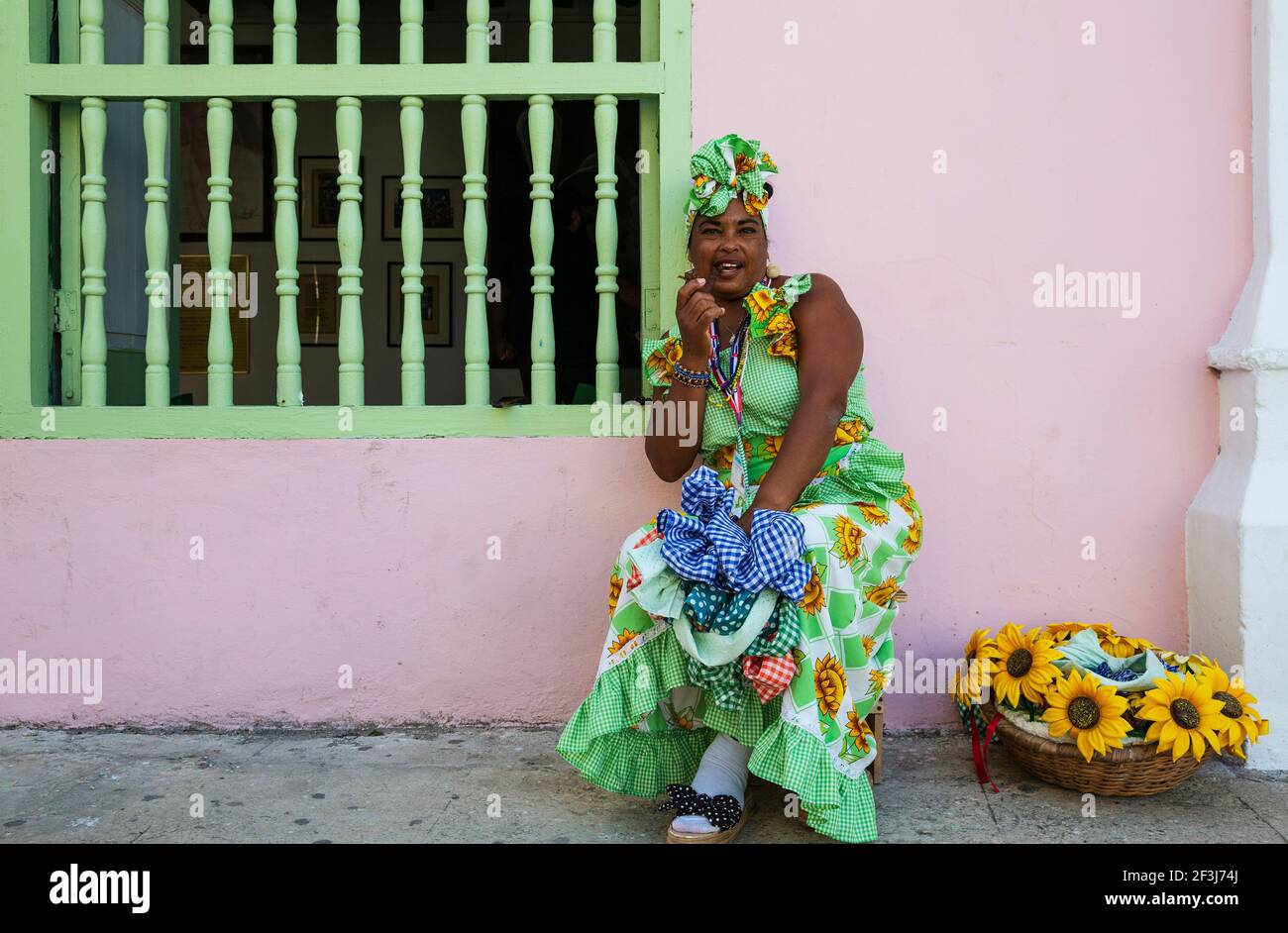 Some women in Habana Vieja wear beautifully coloured dresses and for some money readily pose for photographs, Havana, Cuba Stock Photo