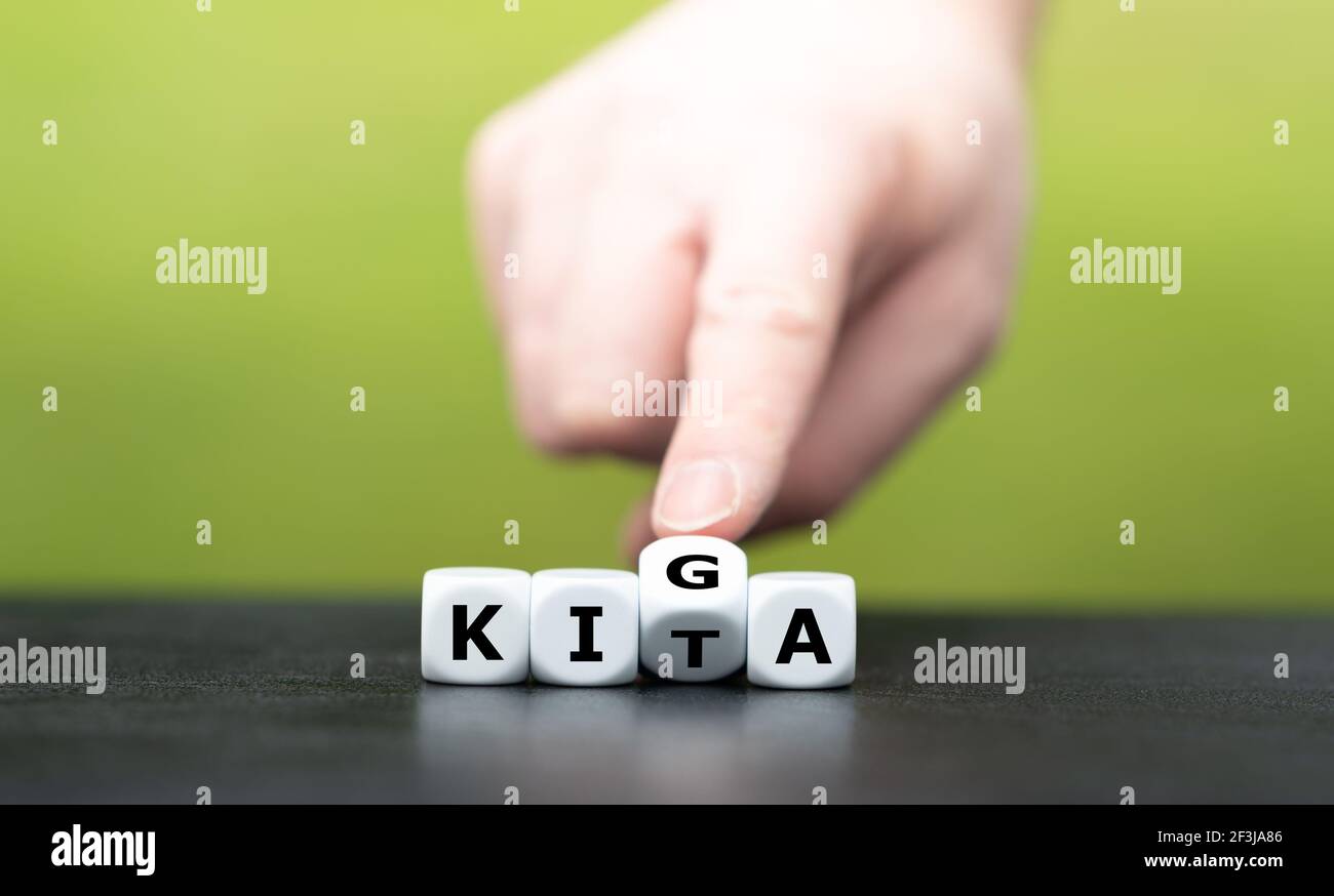  Foto zu Hand turns dice and changes the German abbreviation KITA (daycare) to 