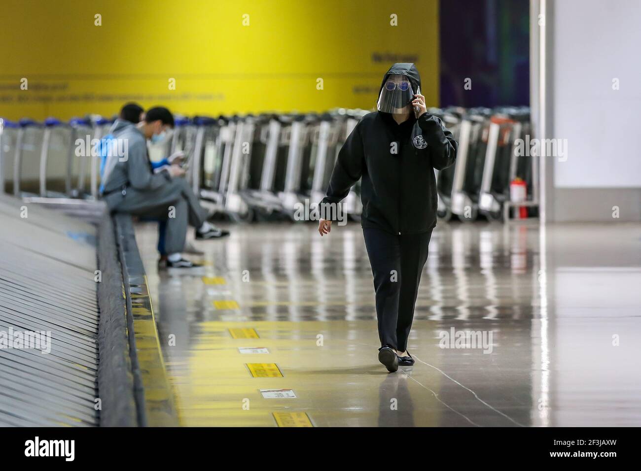 (210317) -- MANILA, March 17, 2021 (Xinhua) -- An airport employee wearing protective shield walks inside the Terminal 1 of the Ninoy Aquino International Airport in Manila, the Philippines on March 17, 2021. The Philippines said it will temporarily suspend the entry of foreigners and some citizens as the Southeast Asian country battles a renewed spike in COVID-19 cases. In a statement issued on Tuesday night, the country's coronavirus task force said foreign citizens and returning nationals who had not been working overseas will not be able to enter the country from March 20 until April 19 u Stock Photo