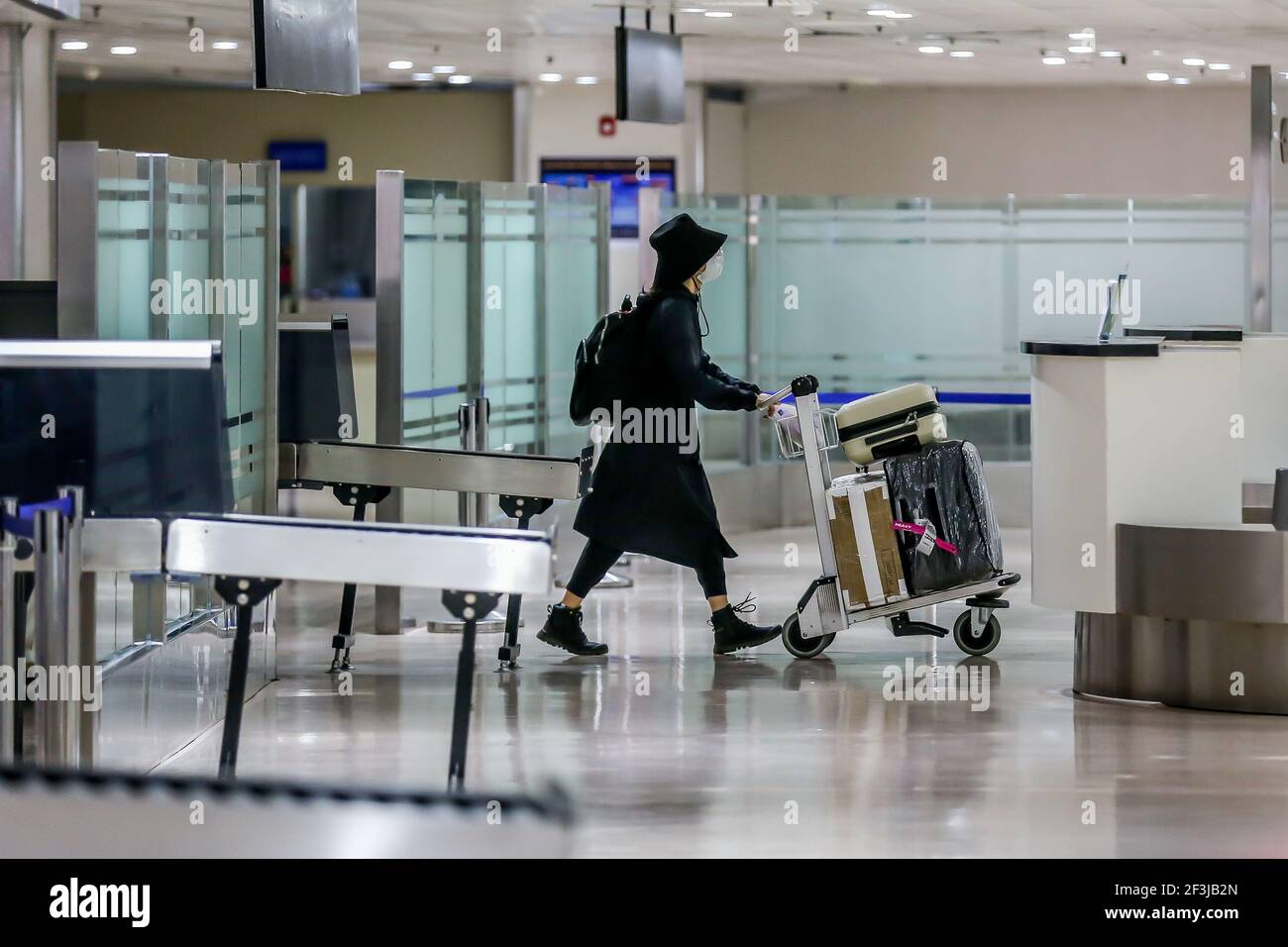 (210317) -- MANILA, March 17, 2021 (Xinhua) -- A passenger wearing a protective mask pushes a baggage cart after arriving at the Terminal 1 of the Ninoy Aquino International Airport in Manila, the Philippines, on March 17, 2021. The Philippines said it will temporarily suspend the entry of foreigners and some citizens as the Southeast Asian country battles a renewed spike in COVID-19 cases. In a statement issued on Tuesday night, the country's coronavirus task force said foreign citizens and returning nationals who had not been working overseas will not be able to enter the country from March Stock Photo