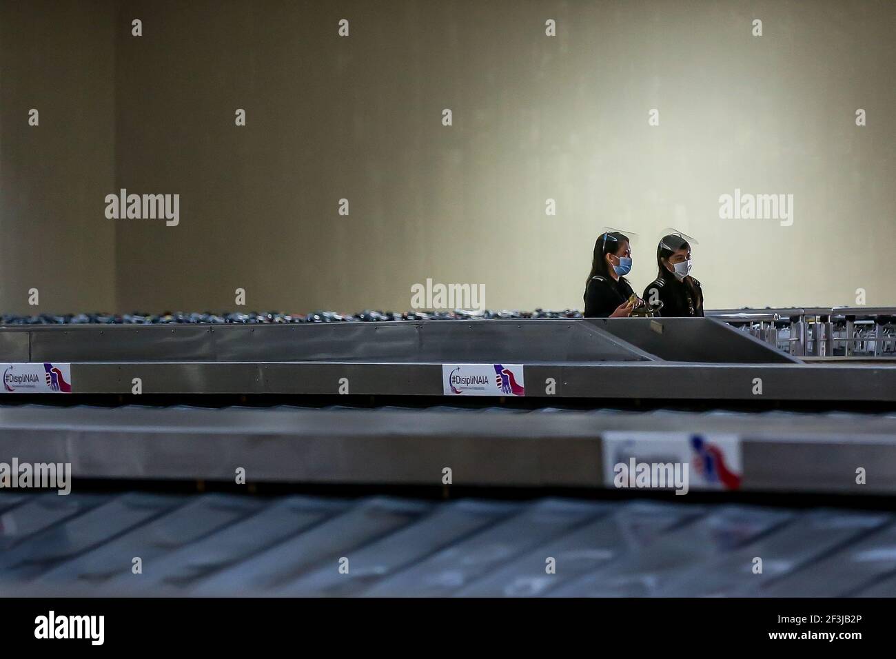 (210317) -- MANILA, March 17, 2021 (Xinhua) -- Airport employees wearing face masks are seen inside the Terminal 1 of the Ninoy Aquino International Airport in Manila, the Philippines, on March 17, 2021. The Philippines said it will temporarily suspend the entry of foreigners and some citizens as the Southeast Asian country battles a renewed spike in COVID-19 cases. In a statement issued on Tuesday night, the country's coronavirus task force said foreign citizens and returning nationals who had not been working overseas will not be able to enter the country from March 20 until April 19 under Stock Photo