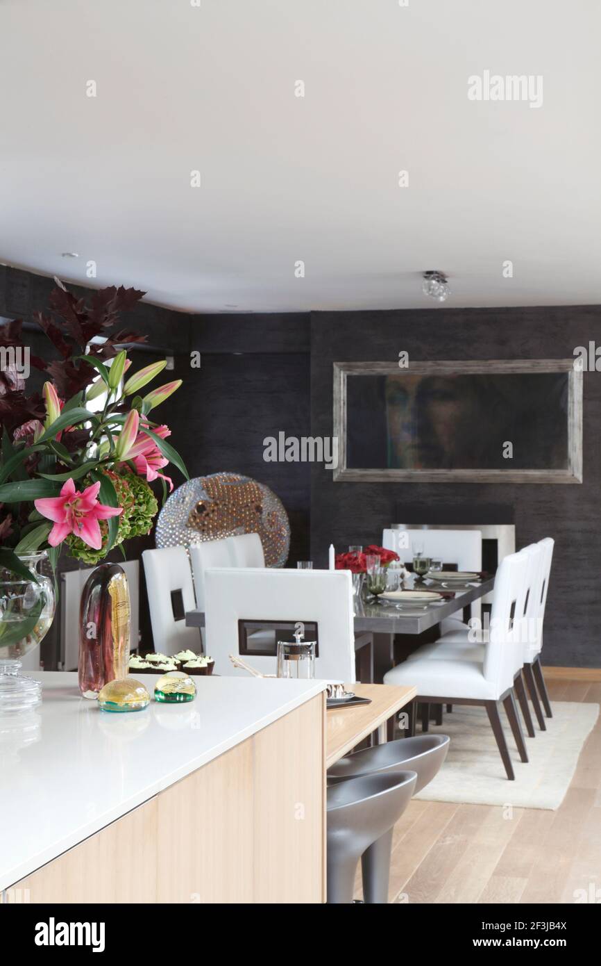 Angled shot of dining area with vase of flowers on kitchen island in foreground |  | Designer: Andrew Wright Stock Photo