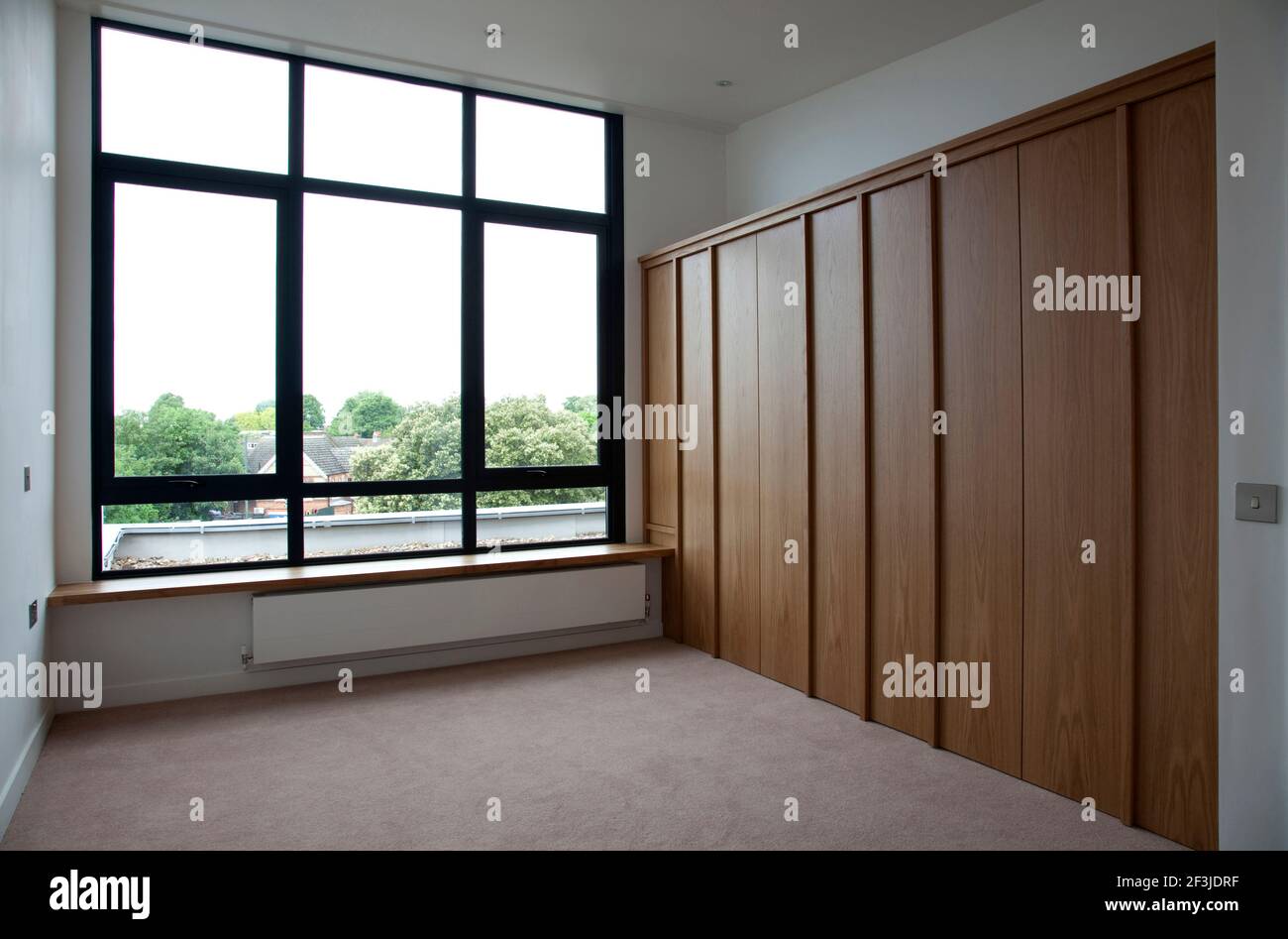 Small empty bedroom with folding storage in Modern Apartments, Hampton
