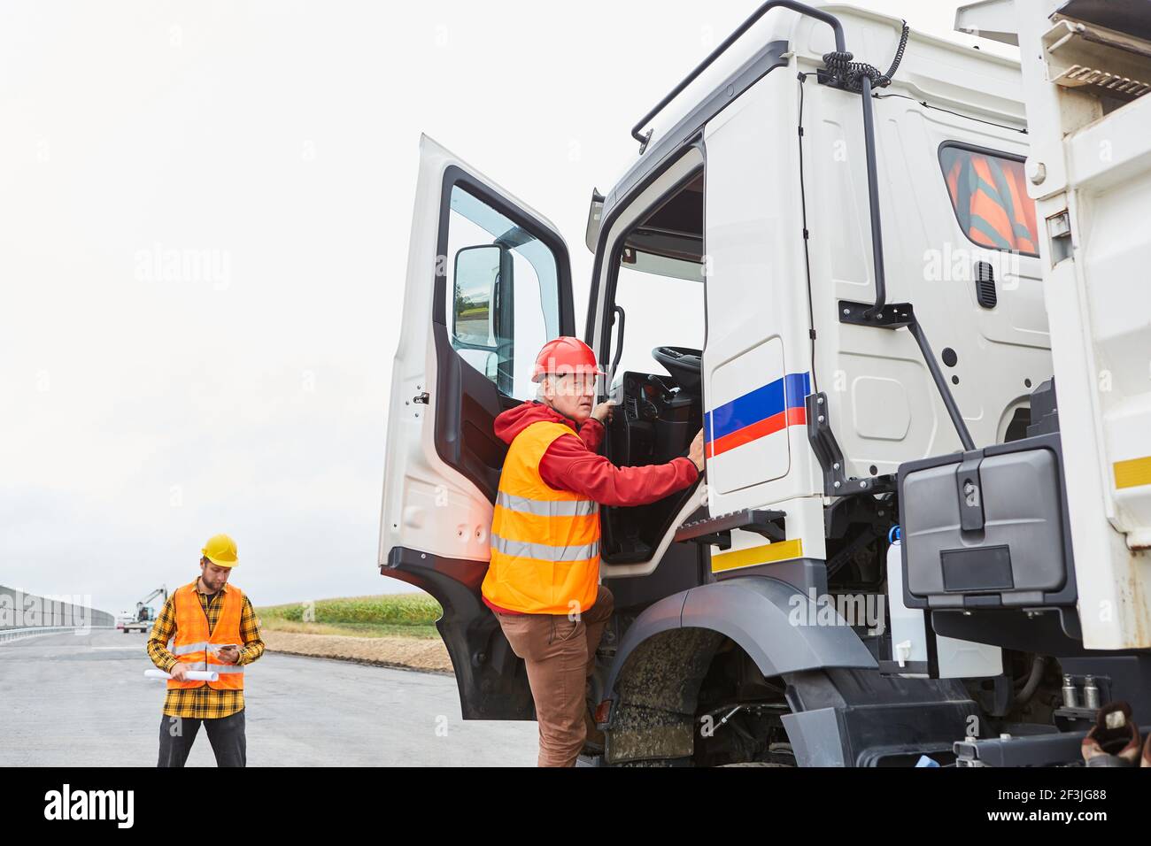 Truck driver climbs into his truck with a delivery for house building
