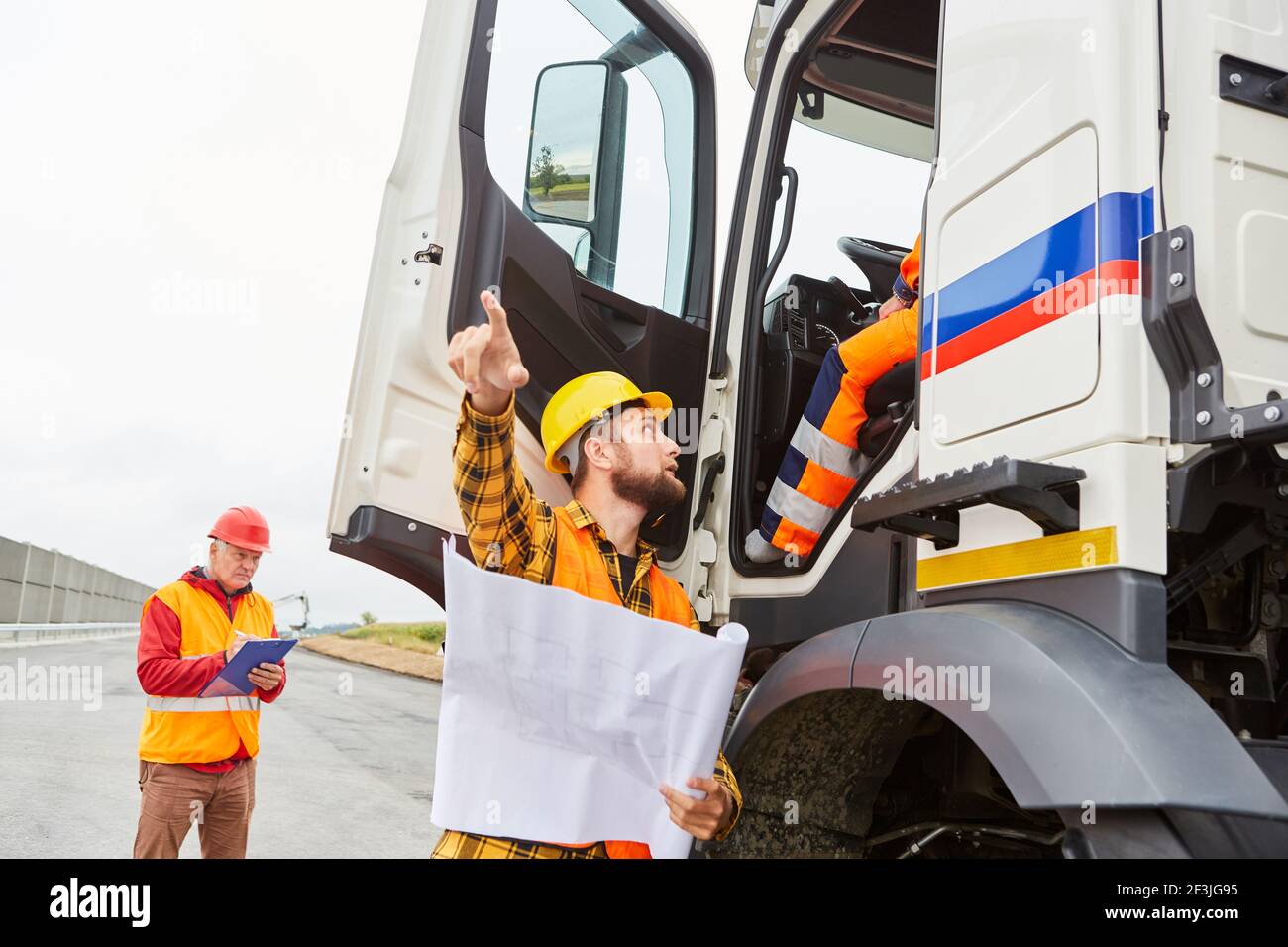 Road construction foreman talks to truck driver about delivery of