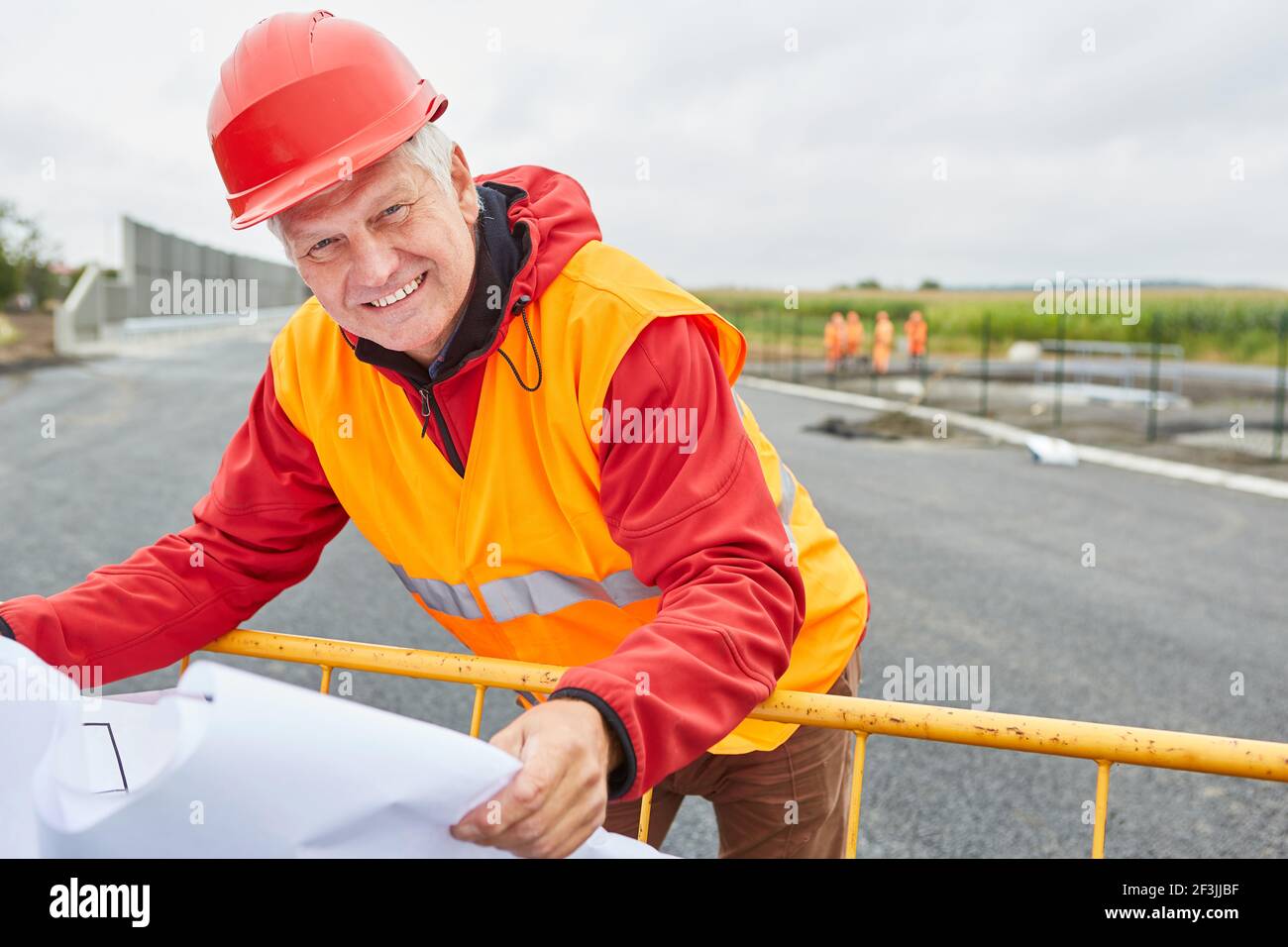 Construction manager or architect with floor plan or site plan on the road construction site Stock Photo