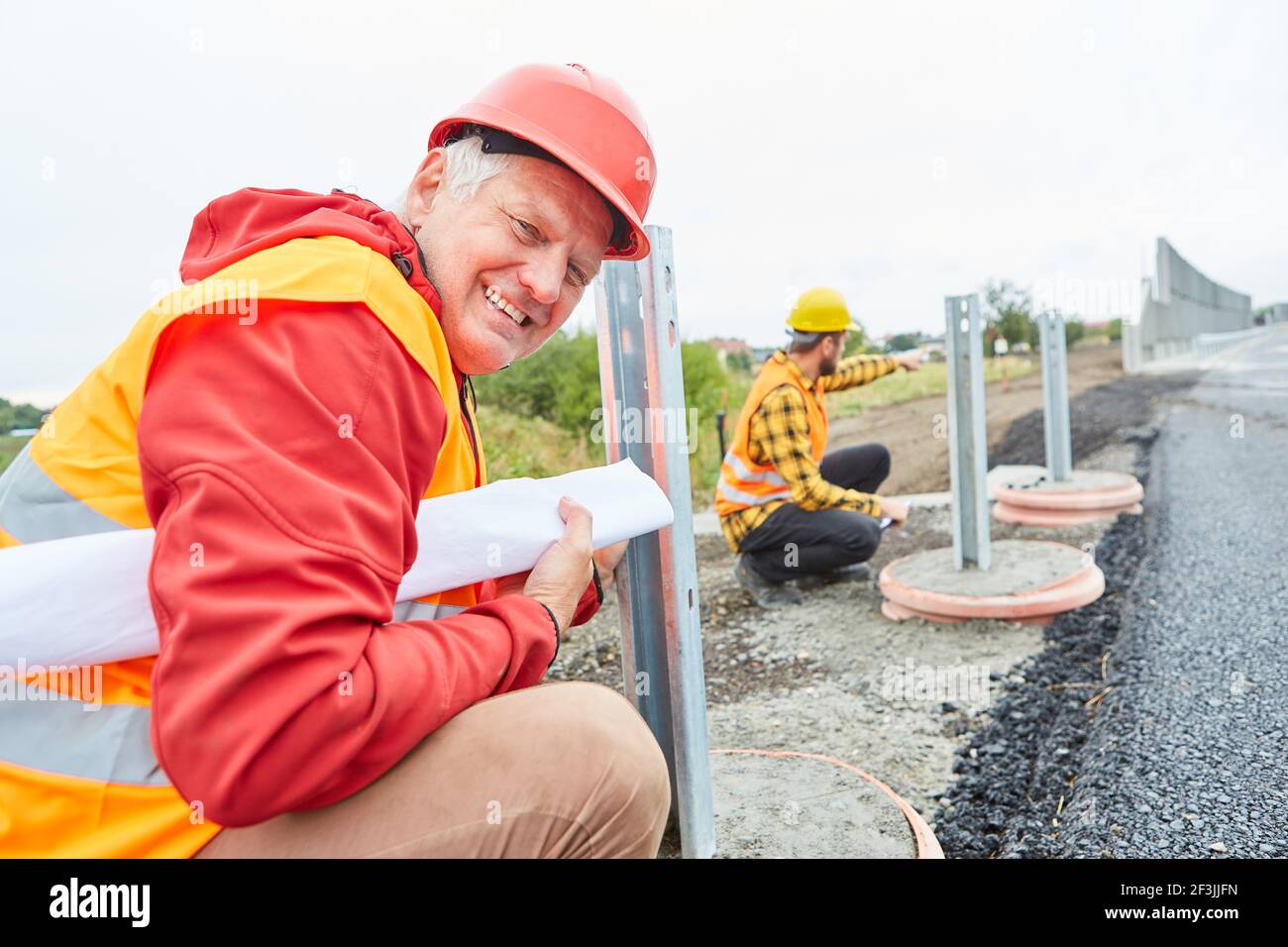 Smiling construction worker on construction site of road construction ...