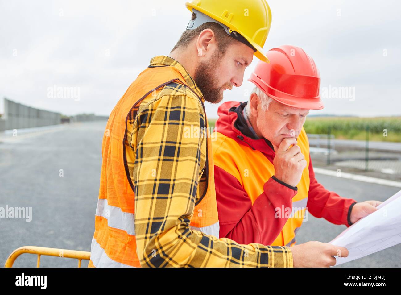 Construction worker and architect look at construction drawing for