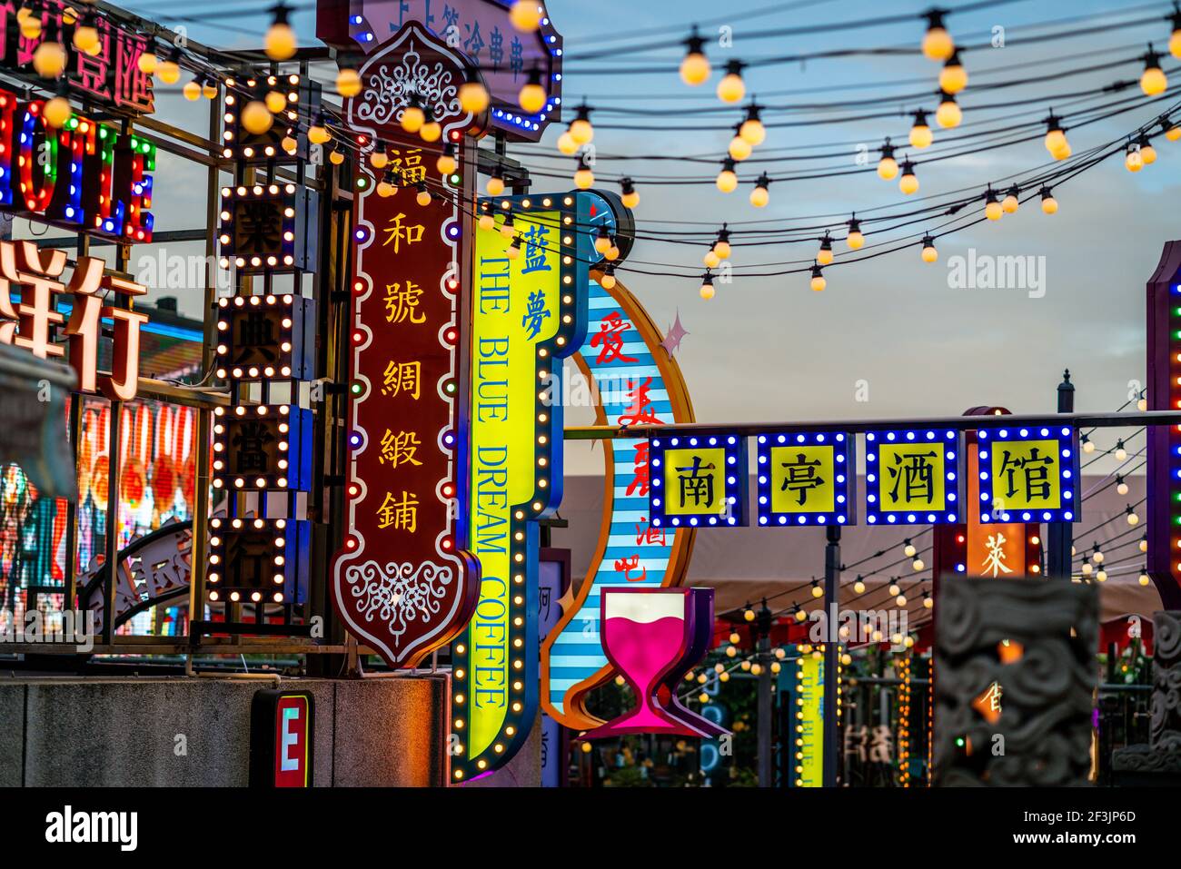 Kunming China , 3 October 2020 : Multicolour restaurants and bars neon sign in Chinese characters illuminated at dusk in Kunming Yunnan China Stock Photo