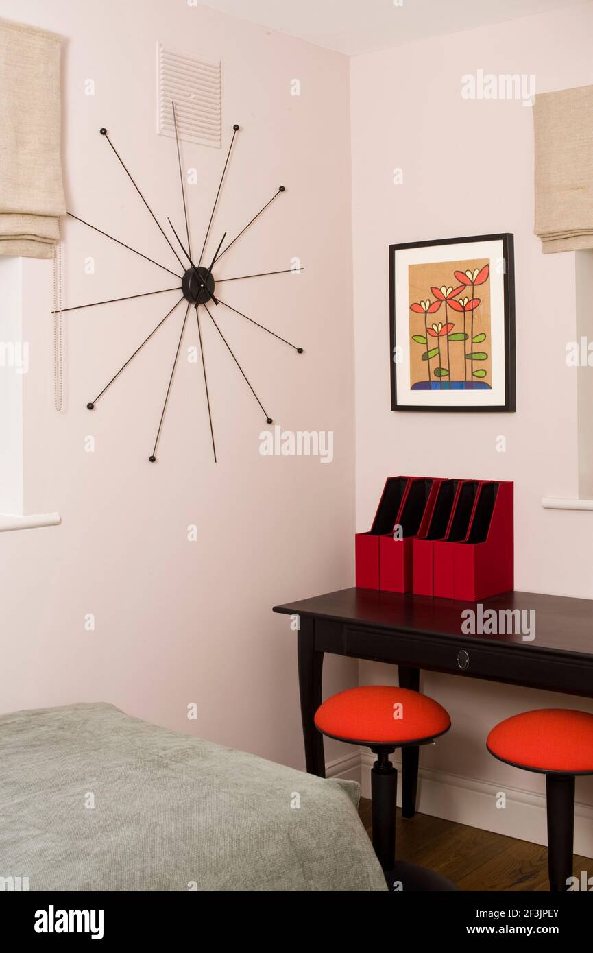 Contemporary wall clock in bedroom with table and storage boxes Photo by Kevin Mcfeely Stock Photo