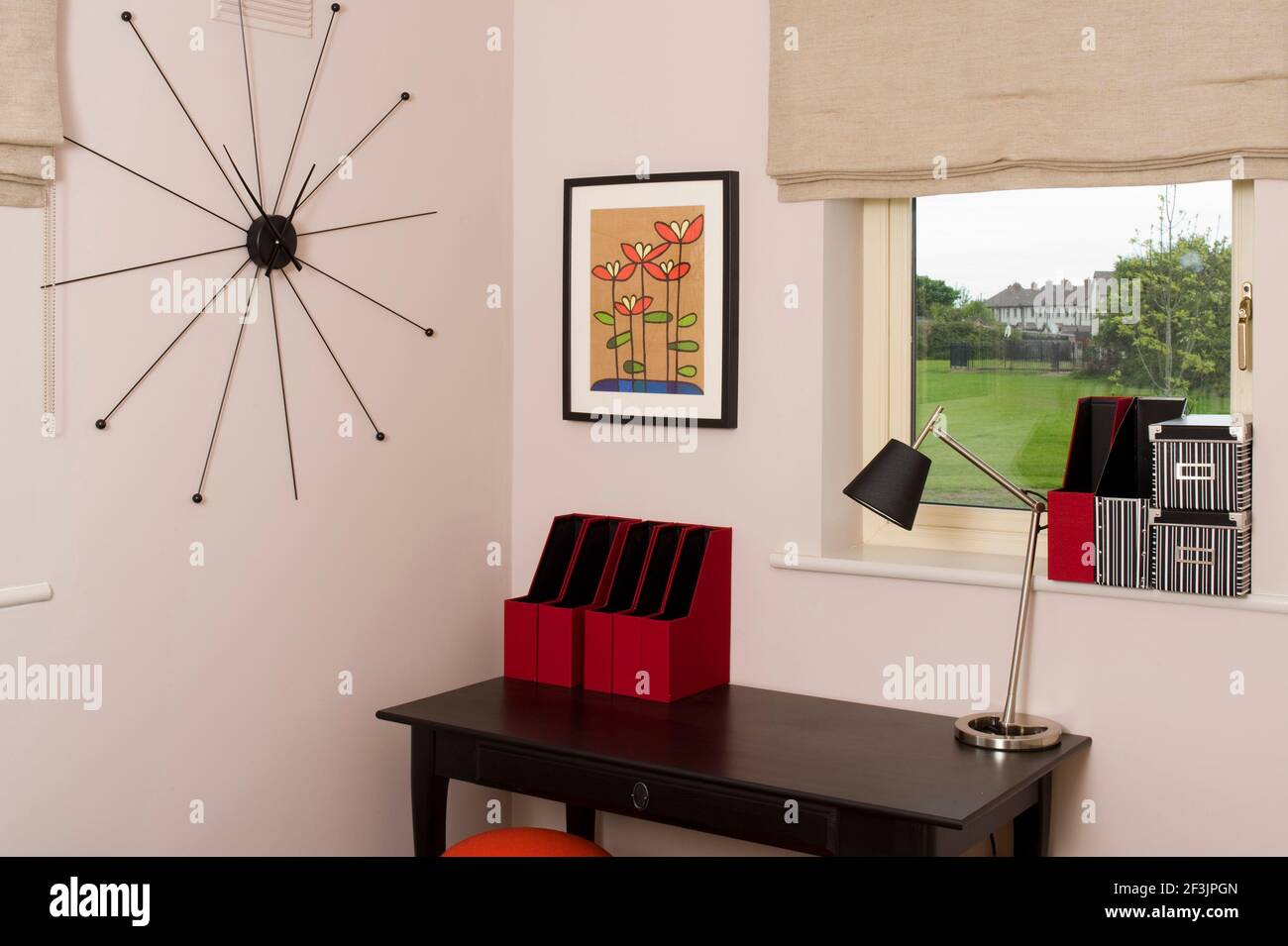 Contemporary wall clock in bedroom with table and storage boxes Photo by Kevin Mcfeely Stock Photo