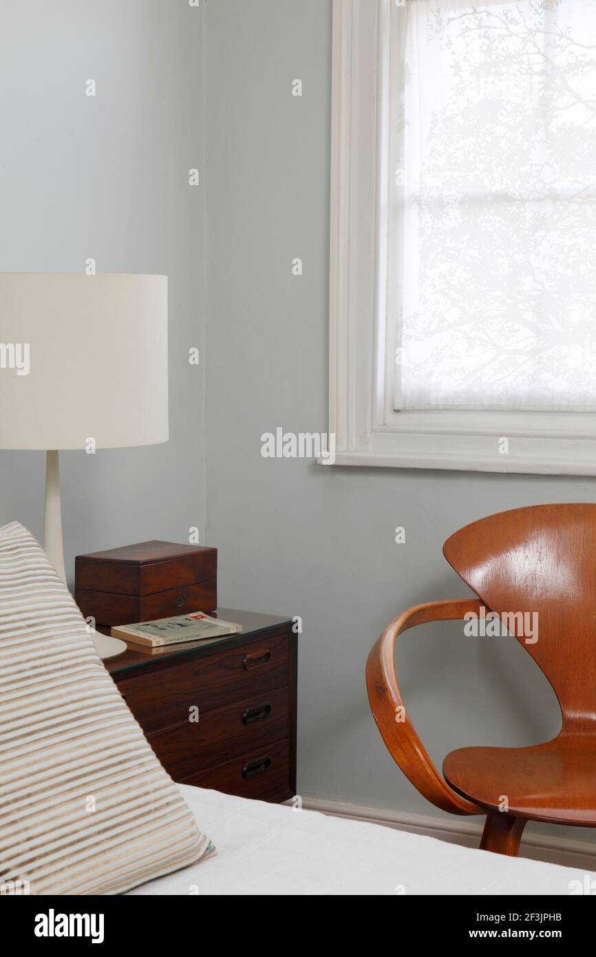 Edge of bed and Paul Cherner chair in front of window Architect