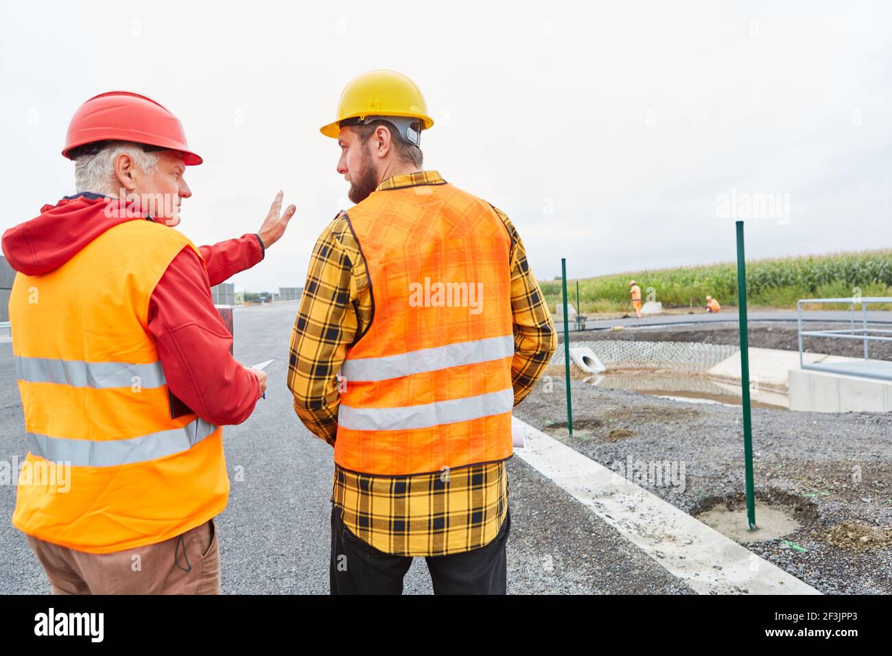 Two construction workers inspecting and developing the road construction site Stock Photo