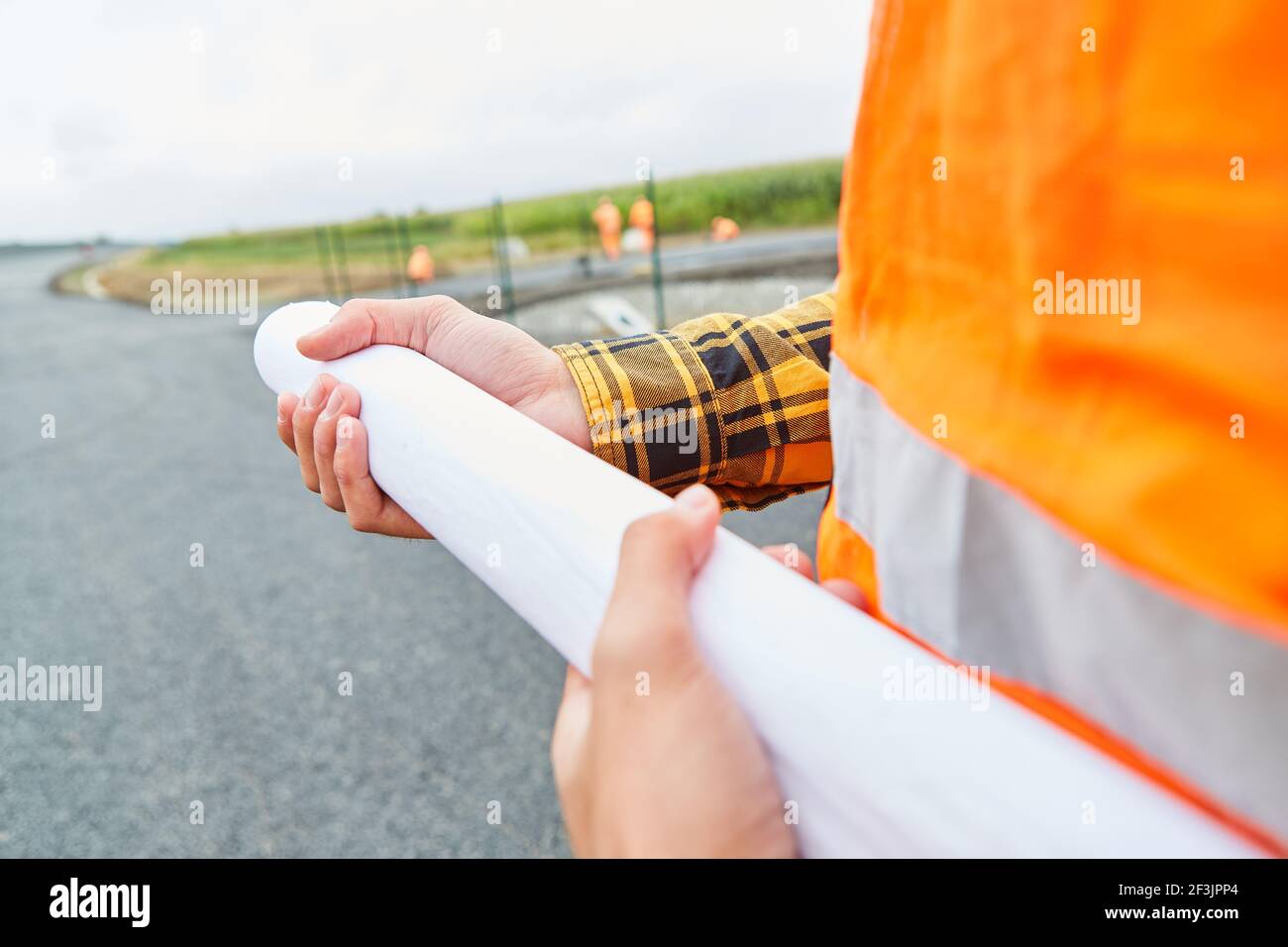 Worker holds a zoning plan or site plan on the construction site of road construction Stock Photo