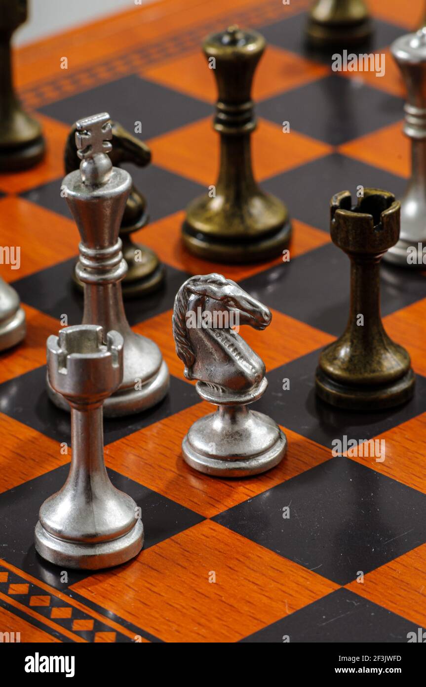 Wooden chess board with metal pieces. Checkmate. Stock Photo