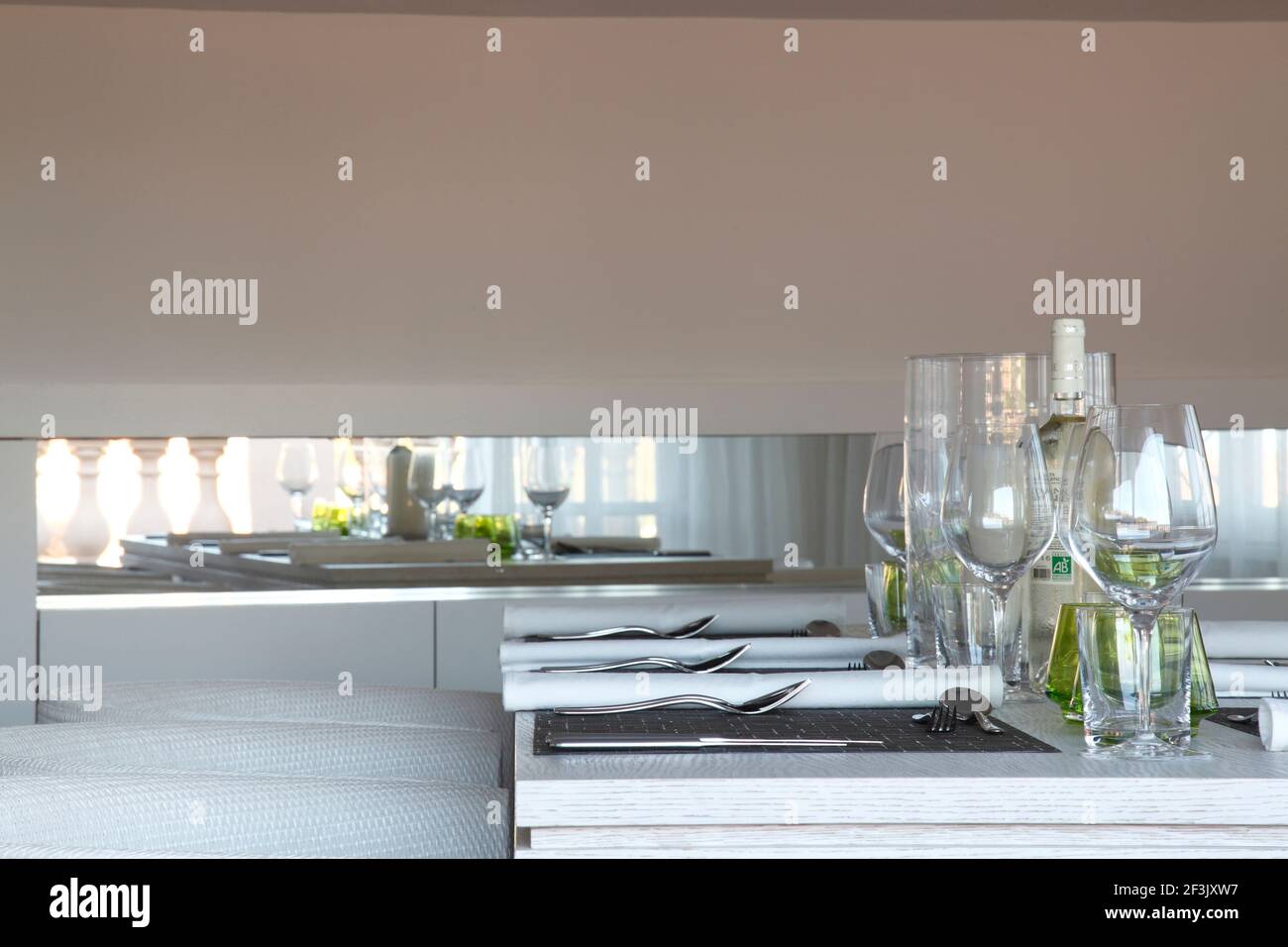 Detail of table setting with reflection in recessed mirror beyond ...