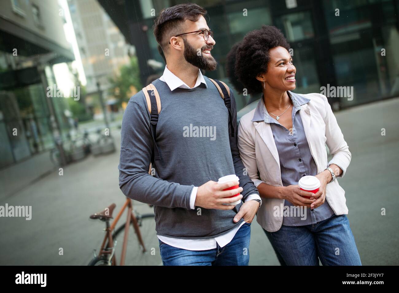 View at young business people talking and smiling outdoors Stock Photo ...