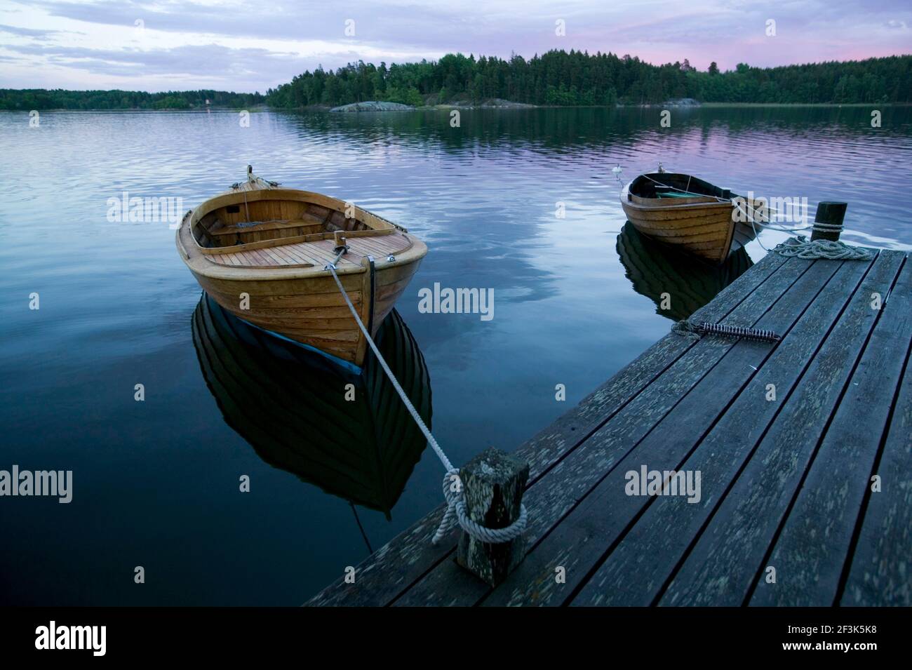 Rowing boats moored on jetty in Vettershaga, Sweden Stock Photo - Alamy