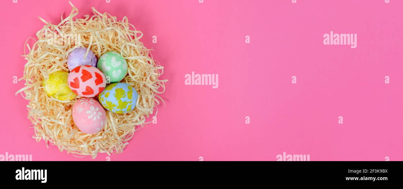 Set with colorful Easter eggs in the nest on pink background, banner ...