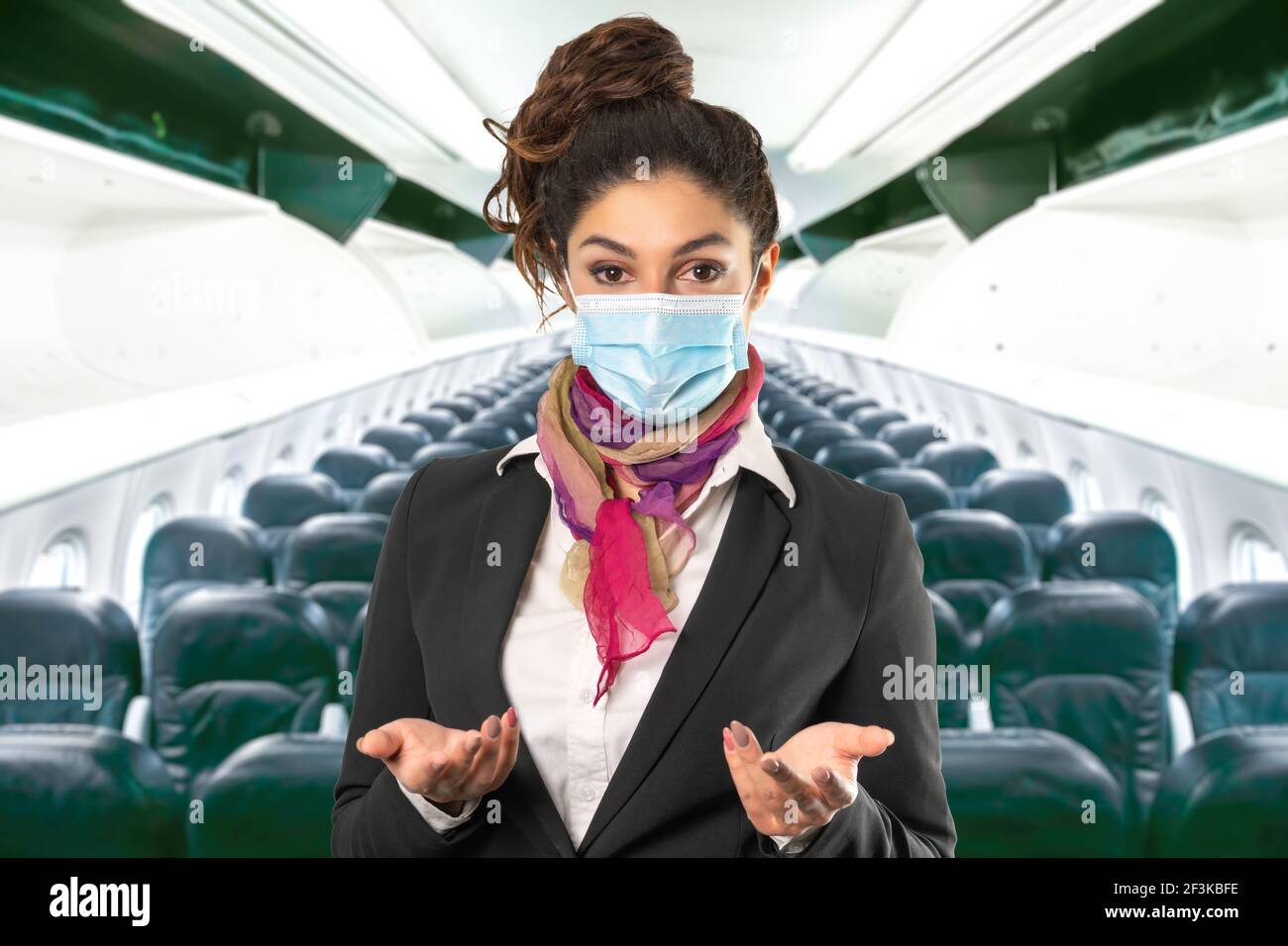 a beautiful flight attendant with surgical mask, multicolored scarf and black jacket. Subject on a blurred background. Perfect shot for women at work, Stock Photo
