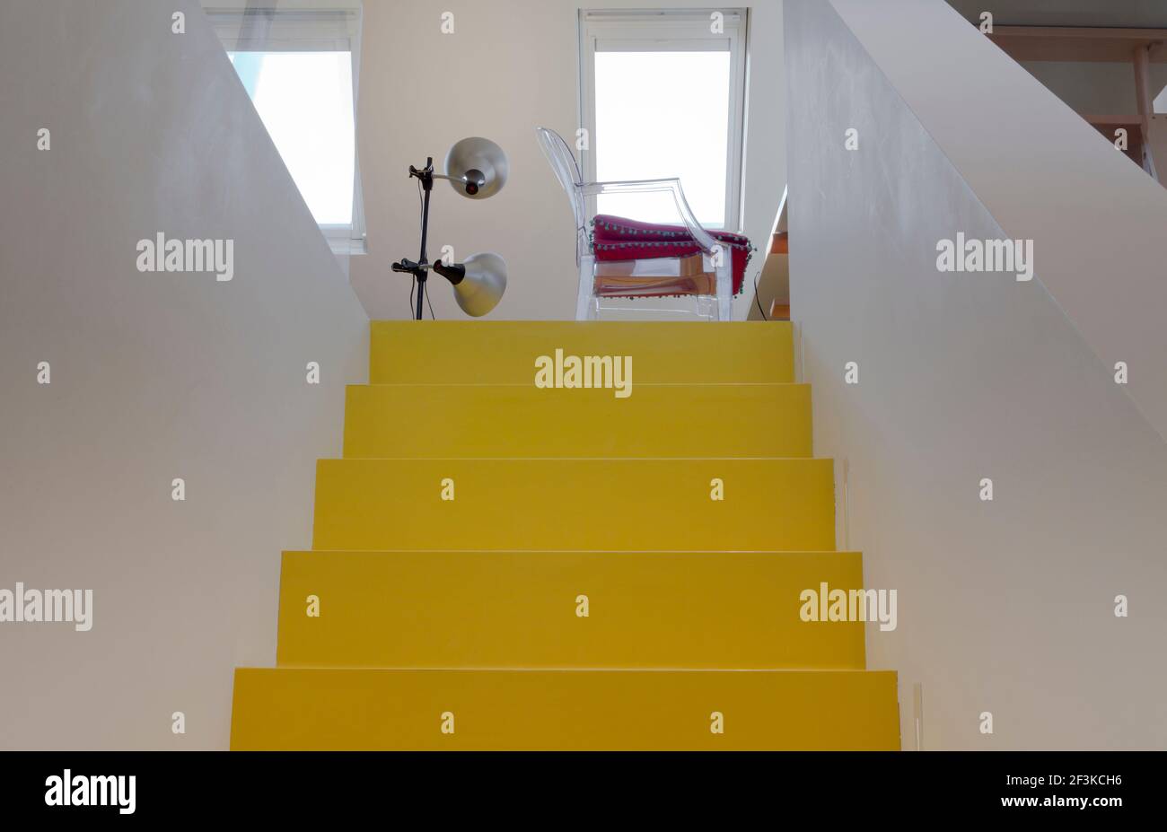 Bright yellow Dalsouple flooring covered stairs lead the way up the Elizath Morgan's atélier/studio/work room in the converted loft space at the top o Stock Photo