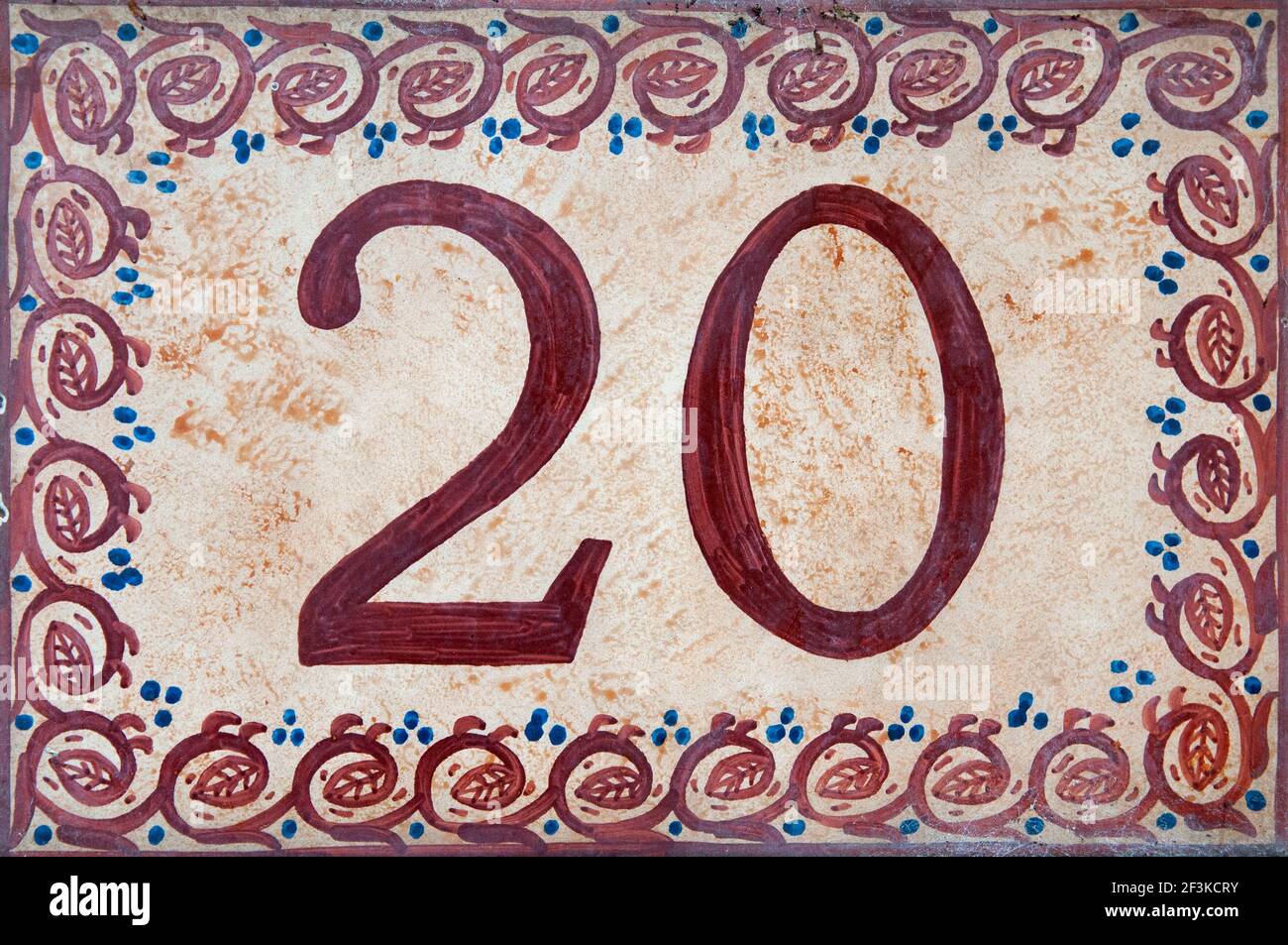 A Close Up Of The Number Twenty Hand Painted On To A Decorative Ceramic Tile Stock Photo