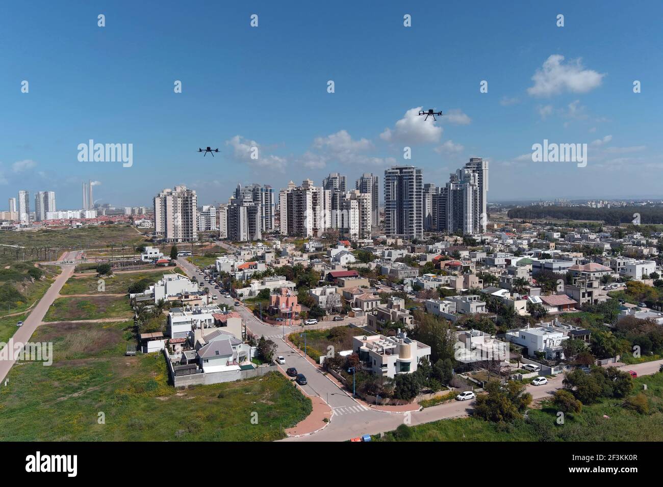 Delivery drones are seen midair during a demonstration whereby drones from various companies flew in a joint airspace and were managed by an autonomous control system in Haifa, as Hadera is seen in the background, Israel March 17, 2021. Picture taken with a drone. REUTERS/Ilan Rosenberg Stock Photo