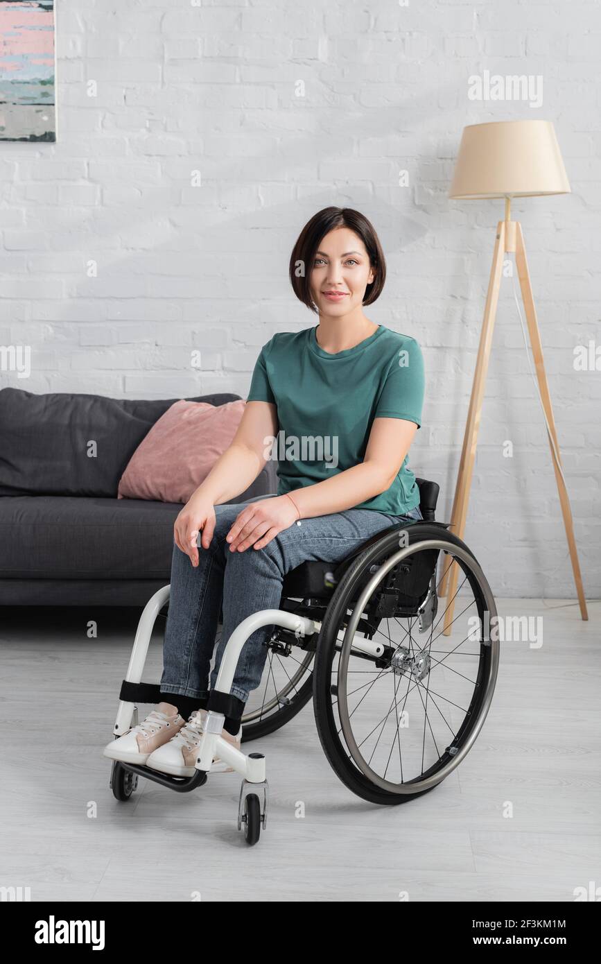 Disabled woman in wheelchair smiling at camera Stock Photo - Alamy