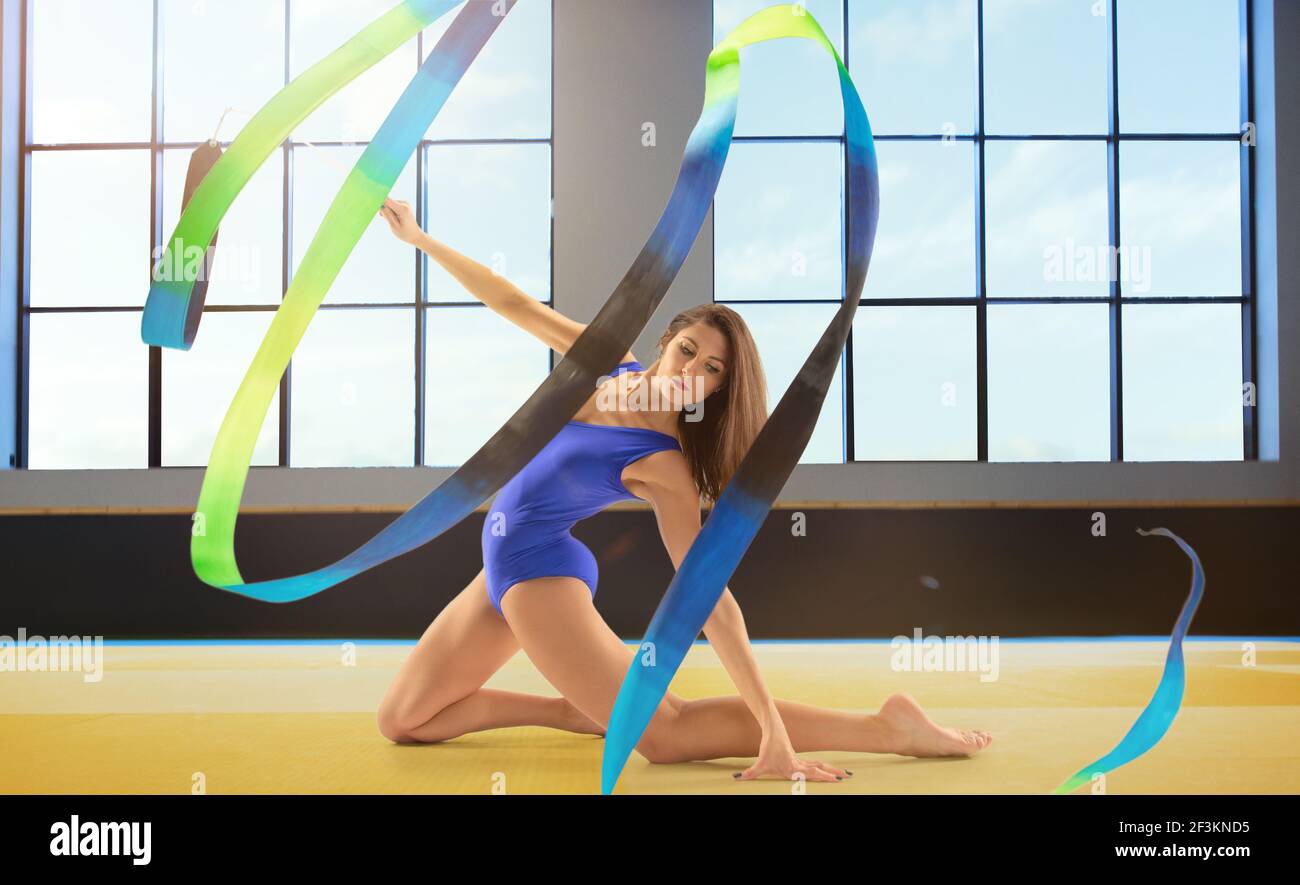 Young flexible female gymnast with bright ribbon training, practicing