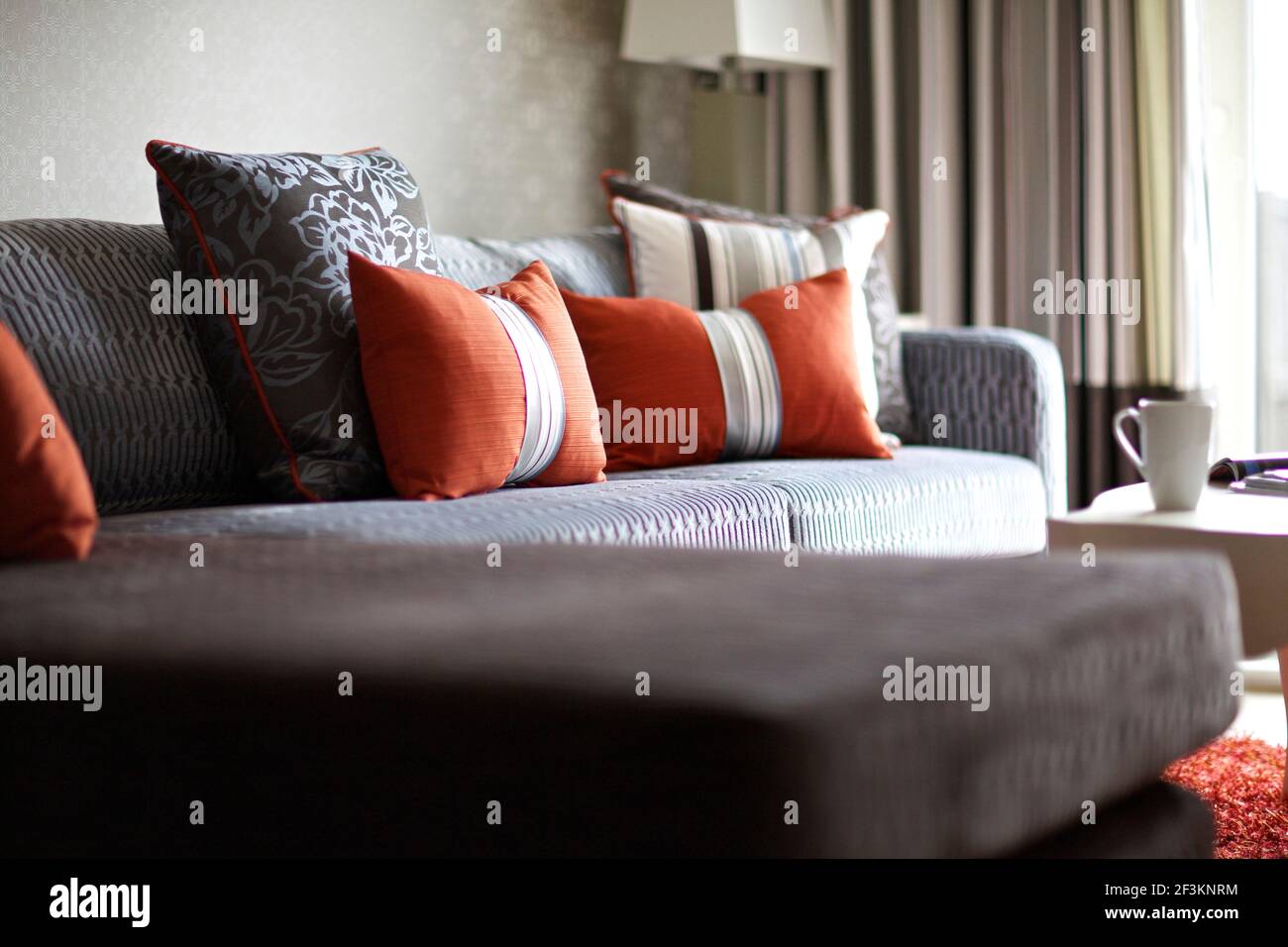 Orange cushions on corner sofa Stock Photo Alamy